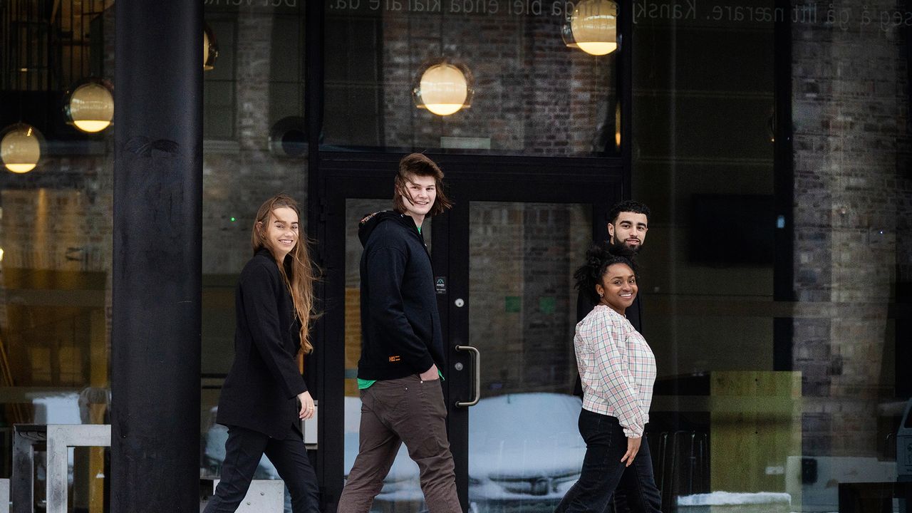 Fire studenter foran skolen