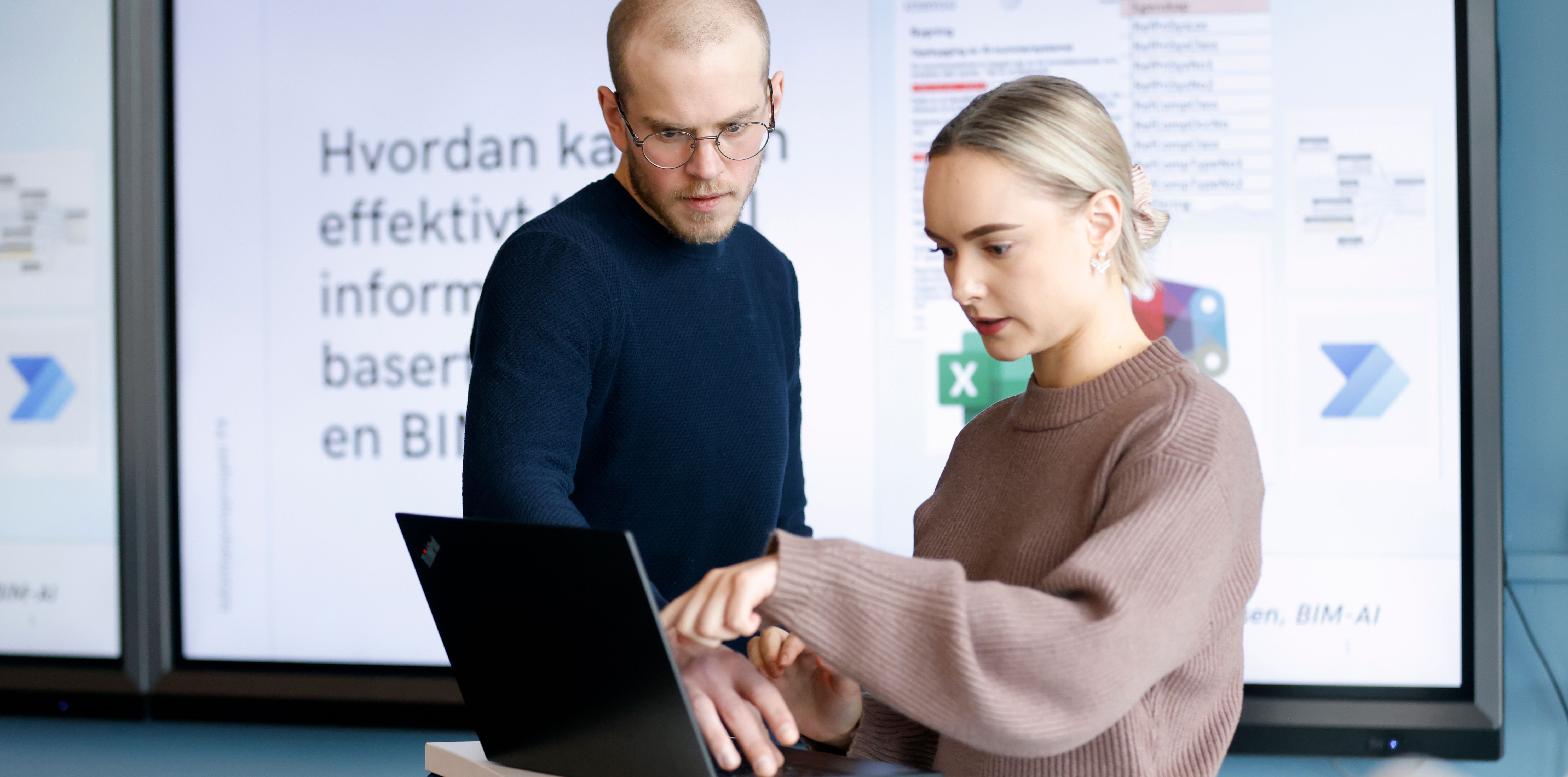 To studenter diskuterer foran en datamaskin