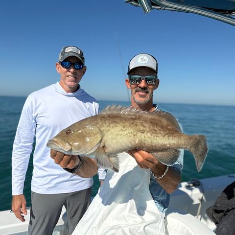 Two anglers on the bow with a gag grouper caught in the Gulf of Mexico