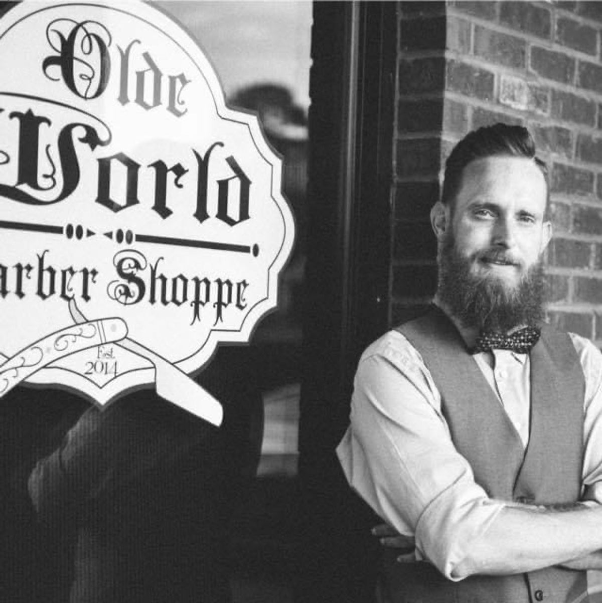 Barber stands proudly outside Olde World Barber Shoppe.