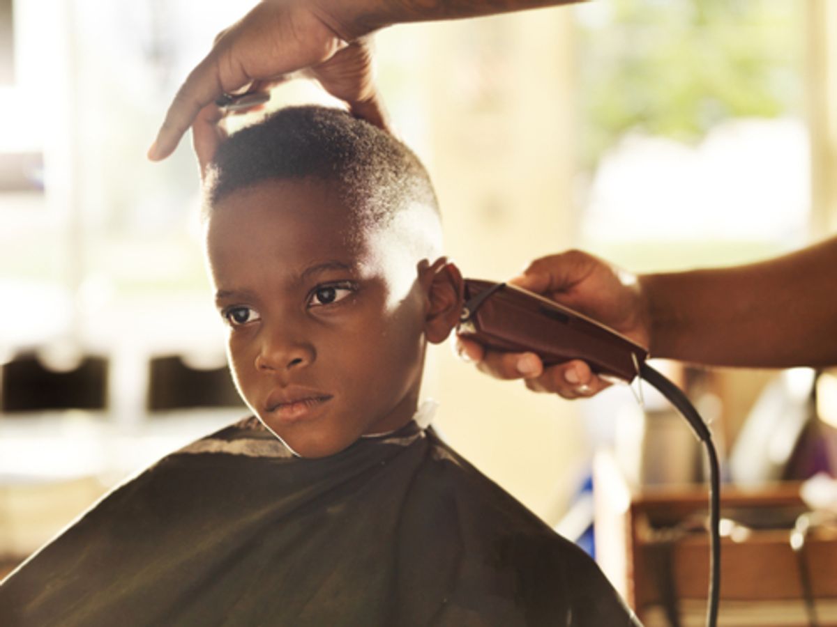 Child getting a haircut from a barber.