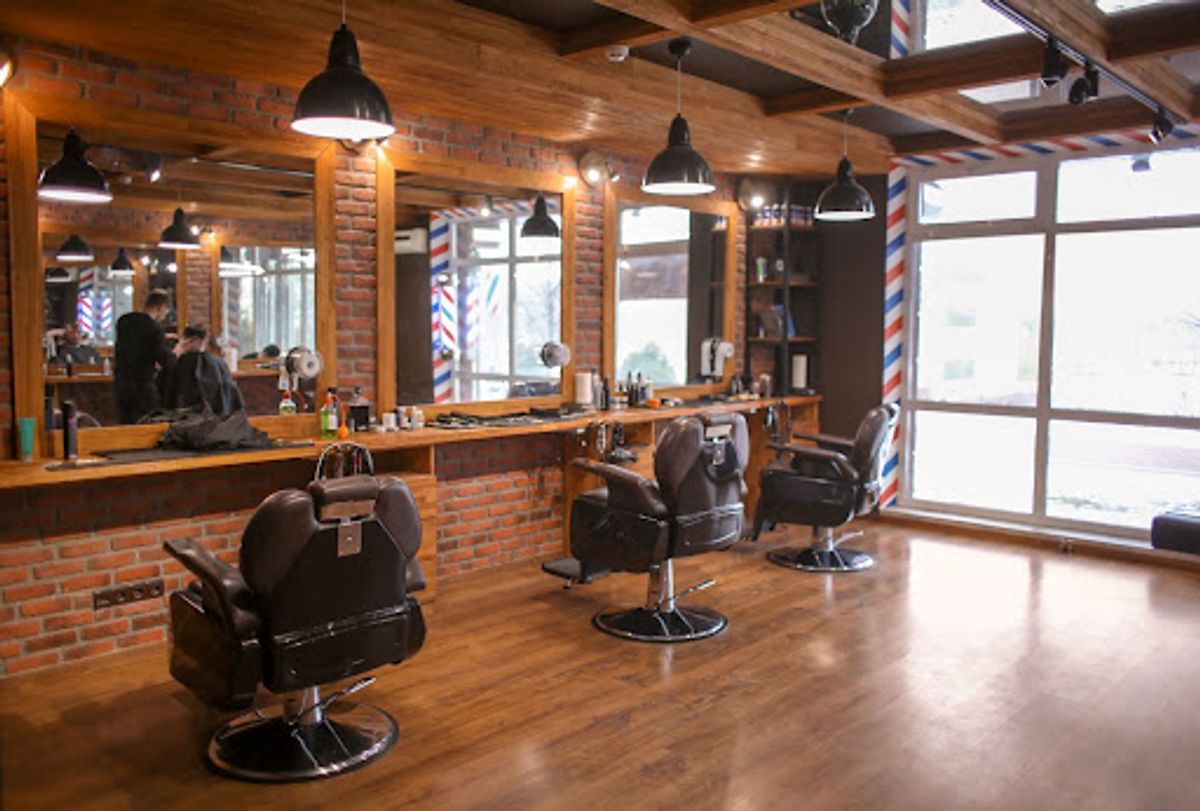 Modern barbershop interior with empty chairs and mirrors.