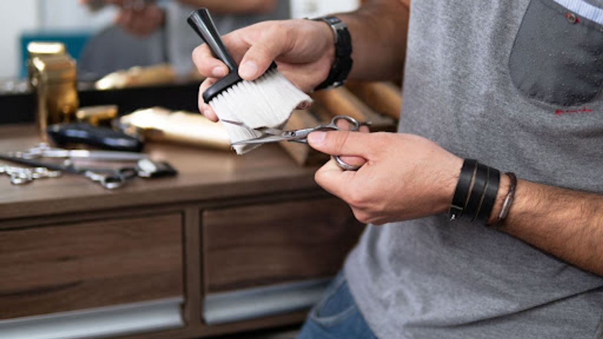Cleaning hairdressing scissors with a brush.