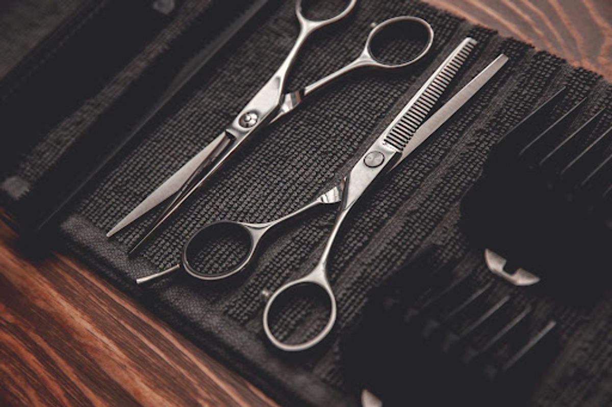 Barber scissors and comb on a tool roll.