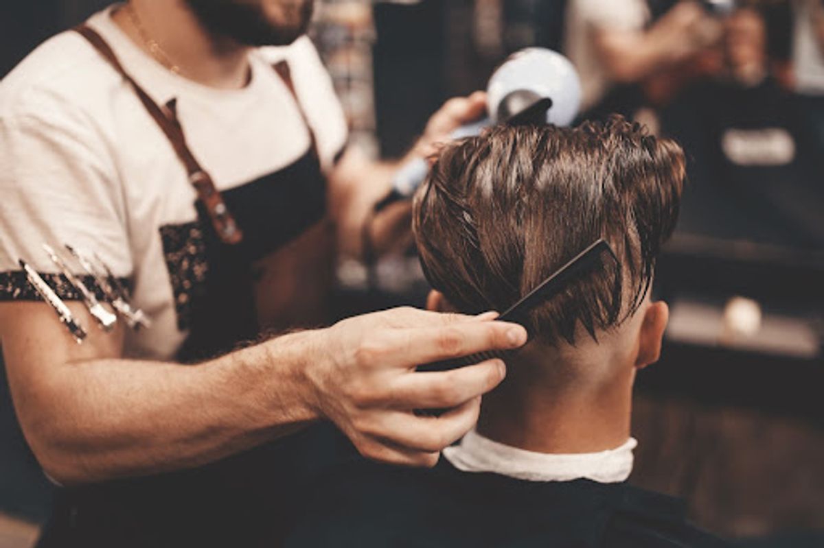 Barber cutting man's hair with precision.
