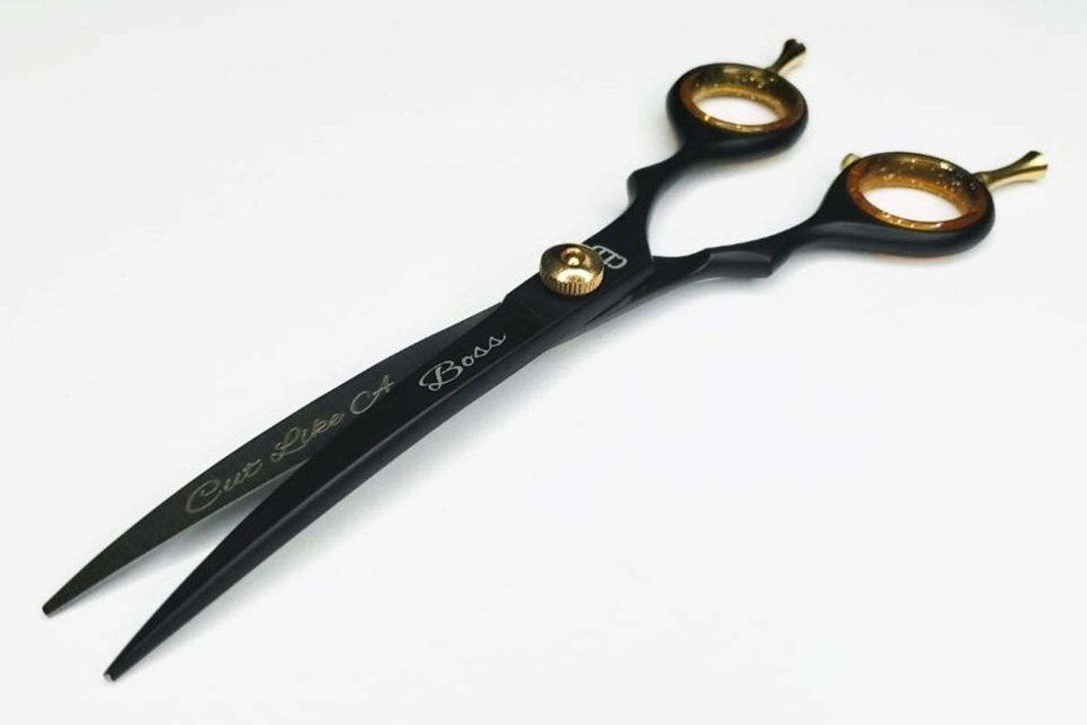 Black and gold hair scissors with decorative text.