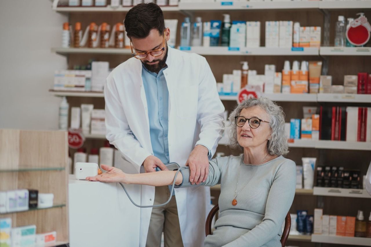 A pharmacist checking a patient's blood pressure