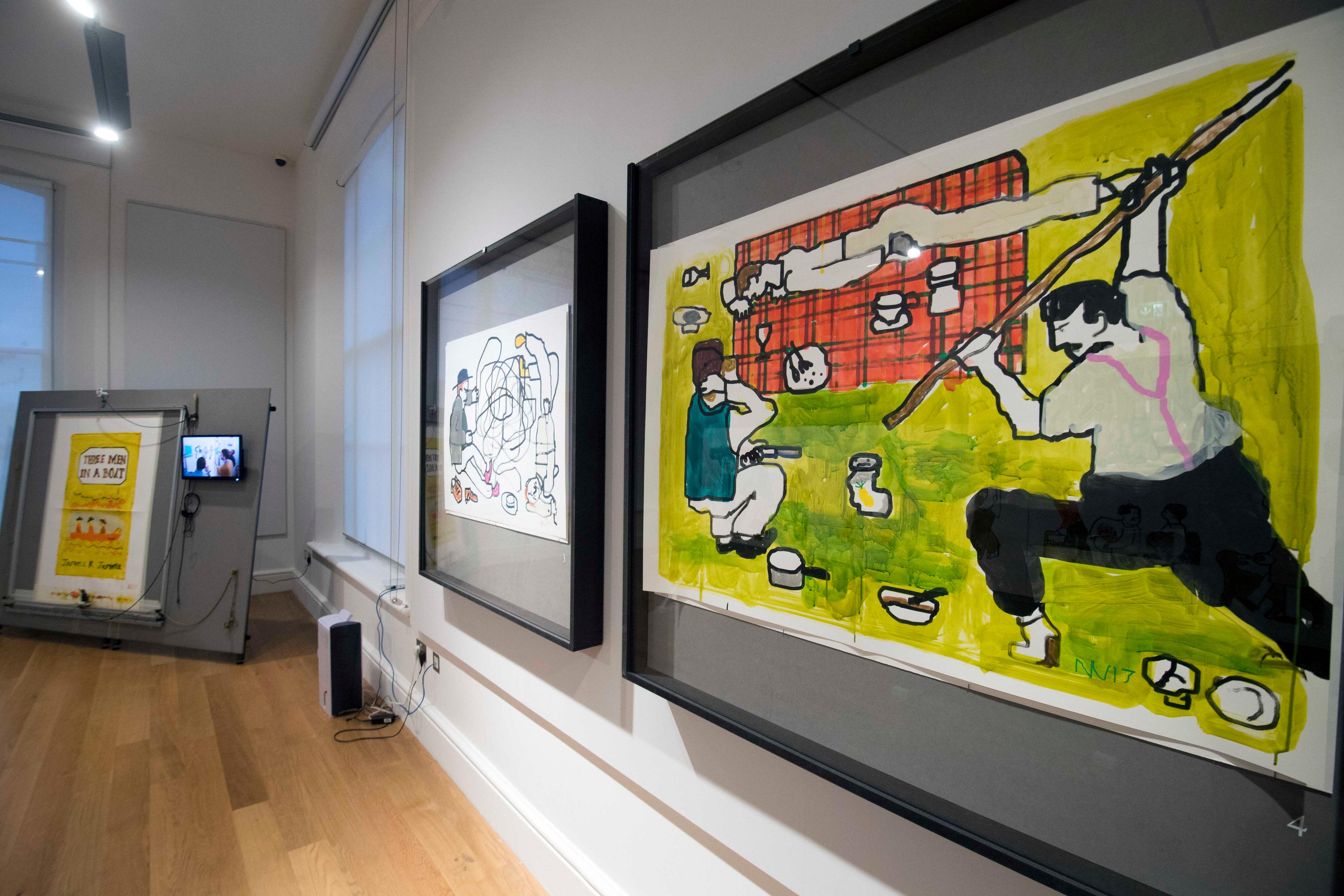 Large framed illustrations on display in an exhibition space.