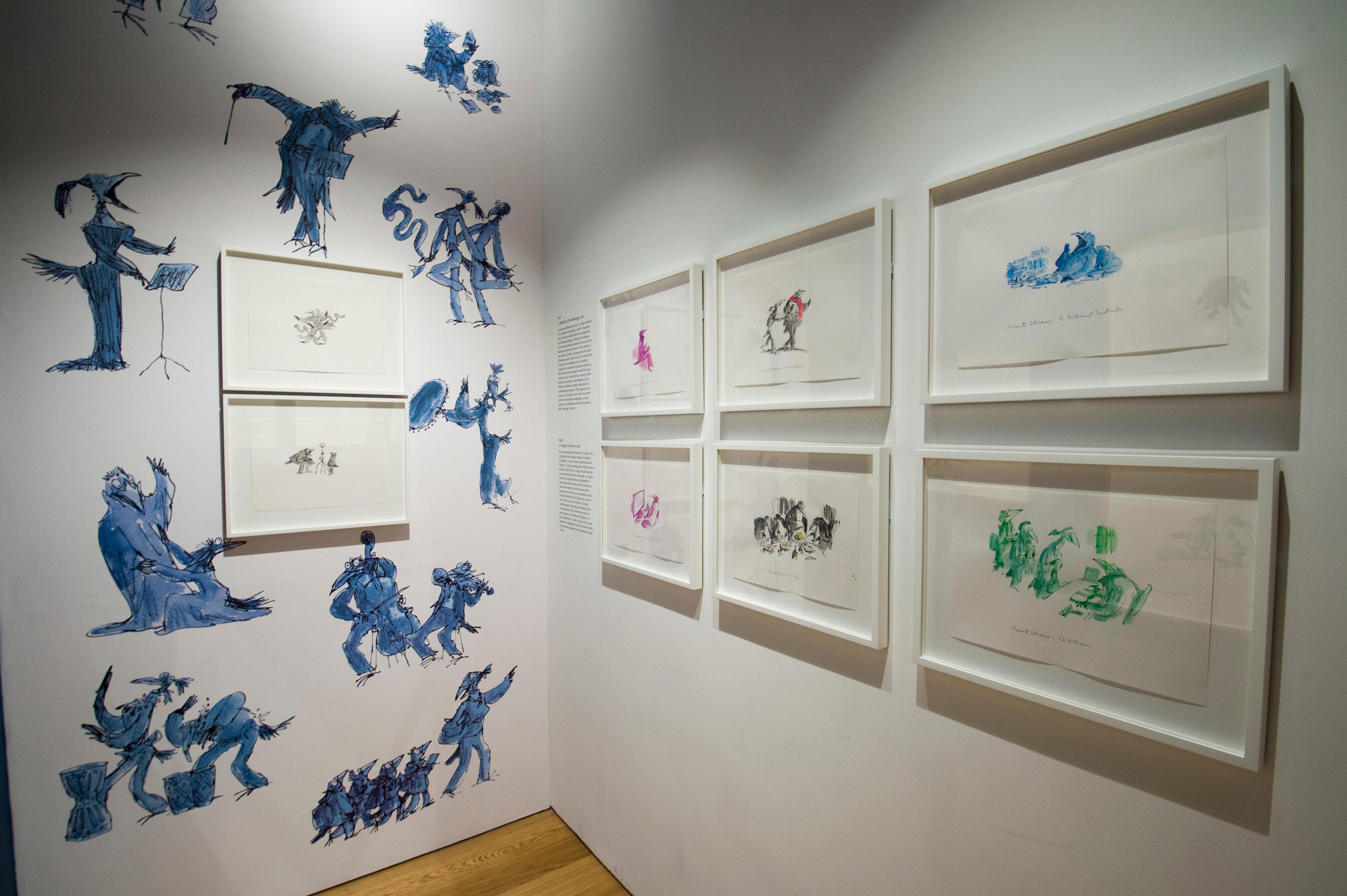 Framed illustrations displayed on two gallery walls. One of the walls is patterned.