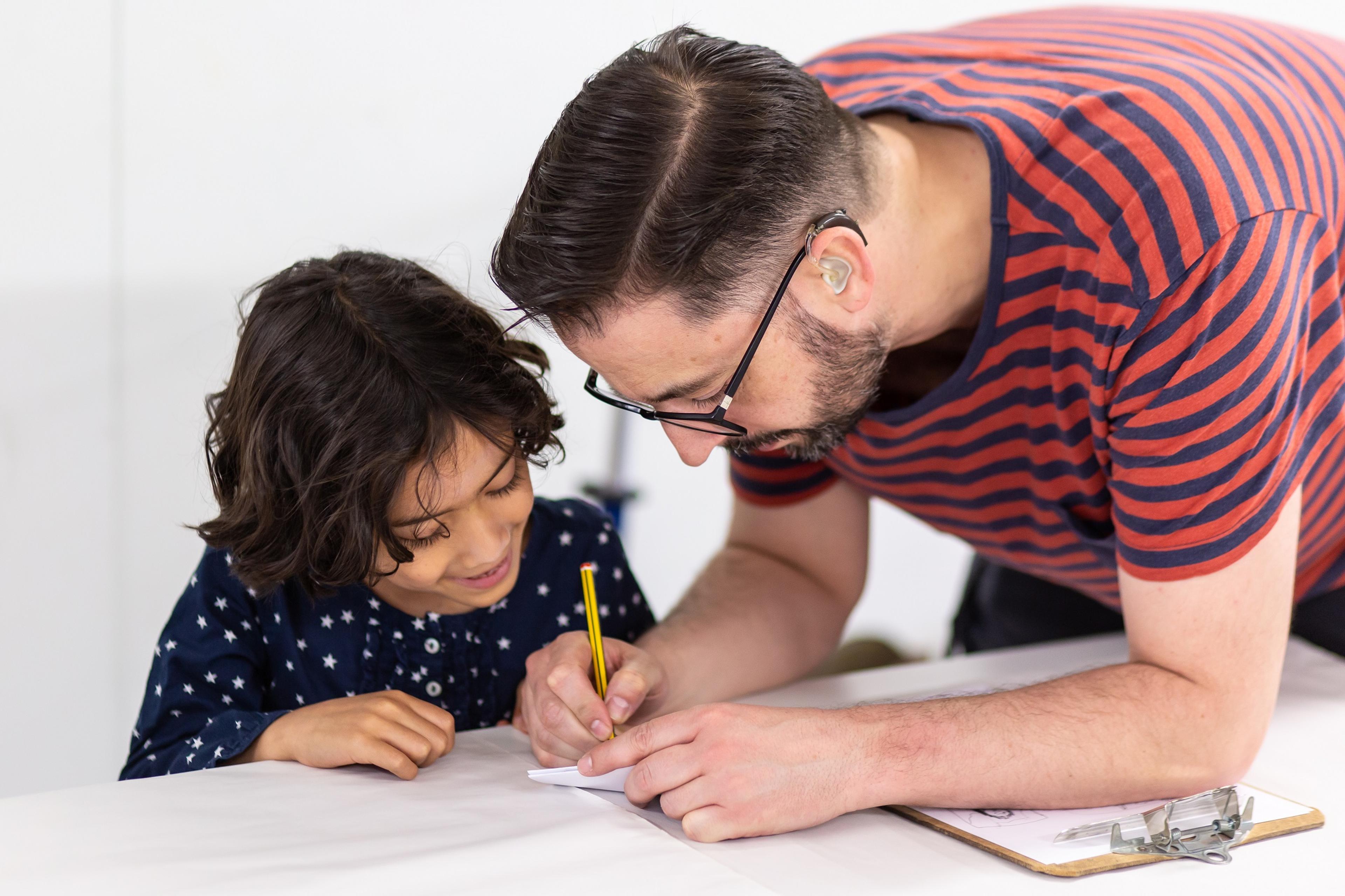 Photograph of adult and child drawing a picture