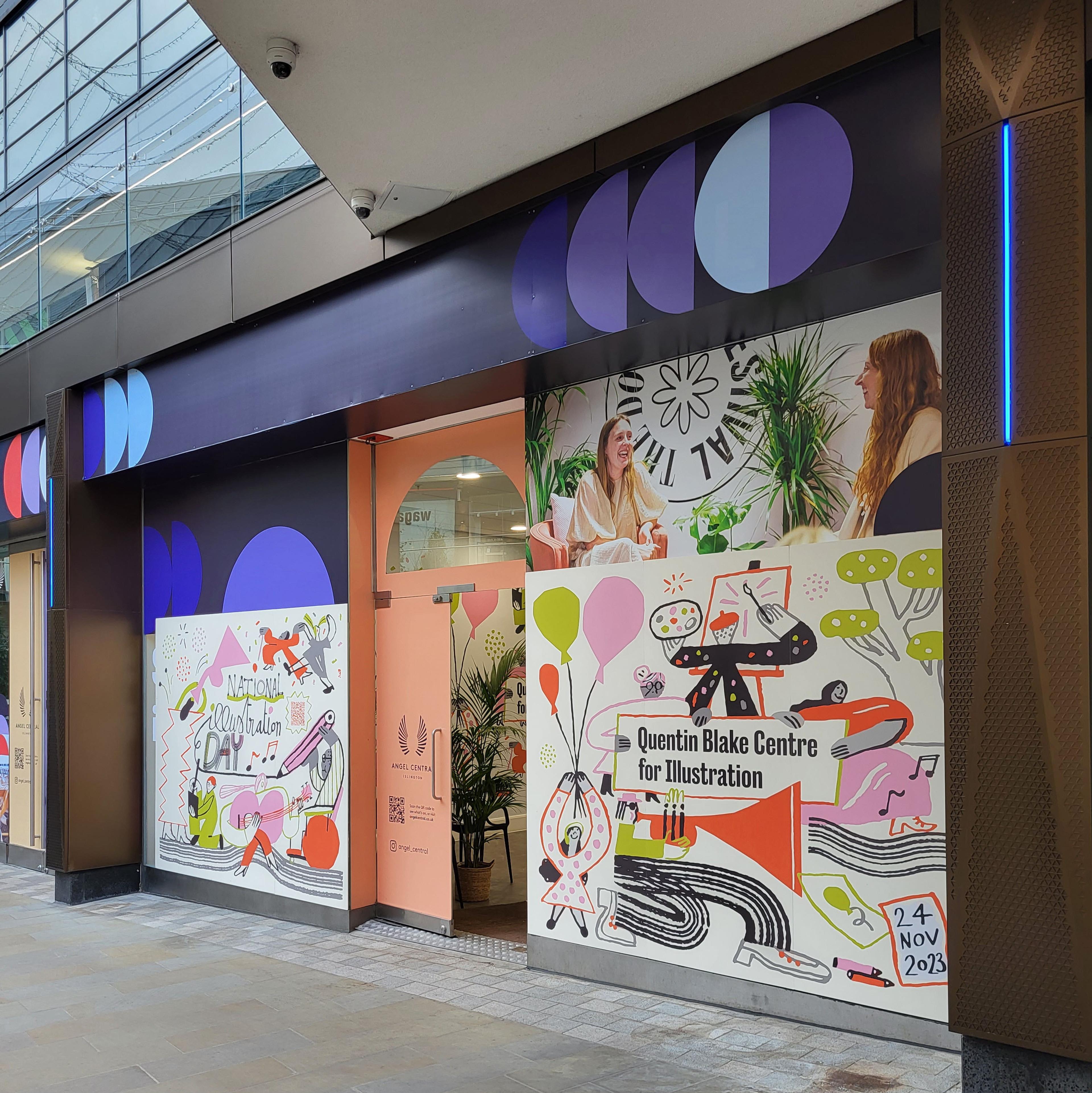 Photograph of the outside of a shop with the windows covered in illustrations.