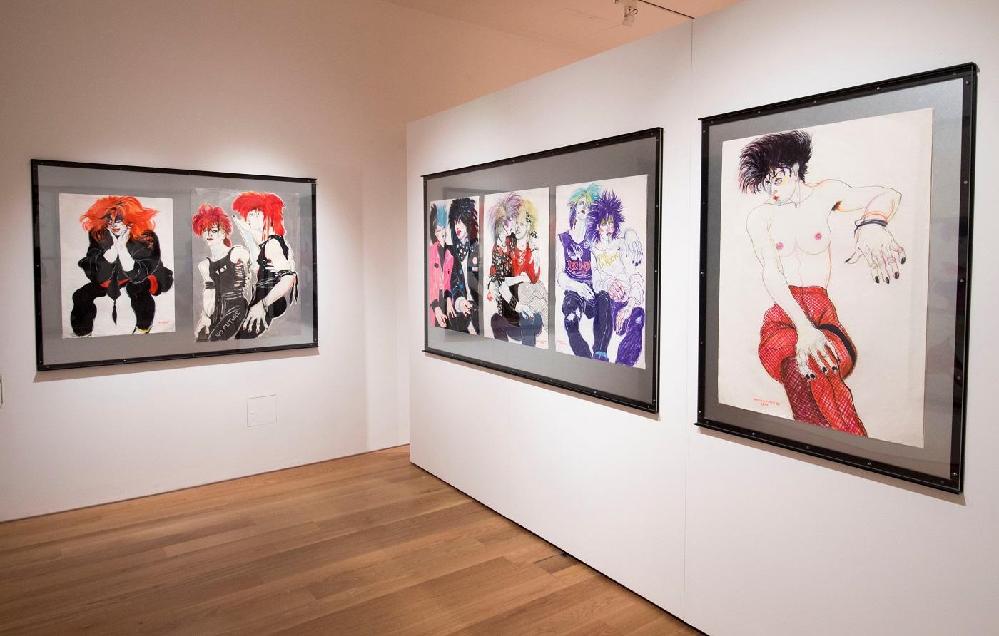 Photograph of large drawings hung on silver sheet metal on white gallery walls