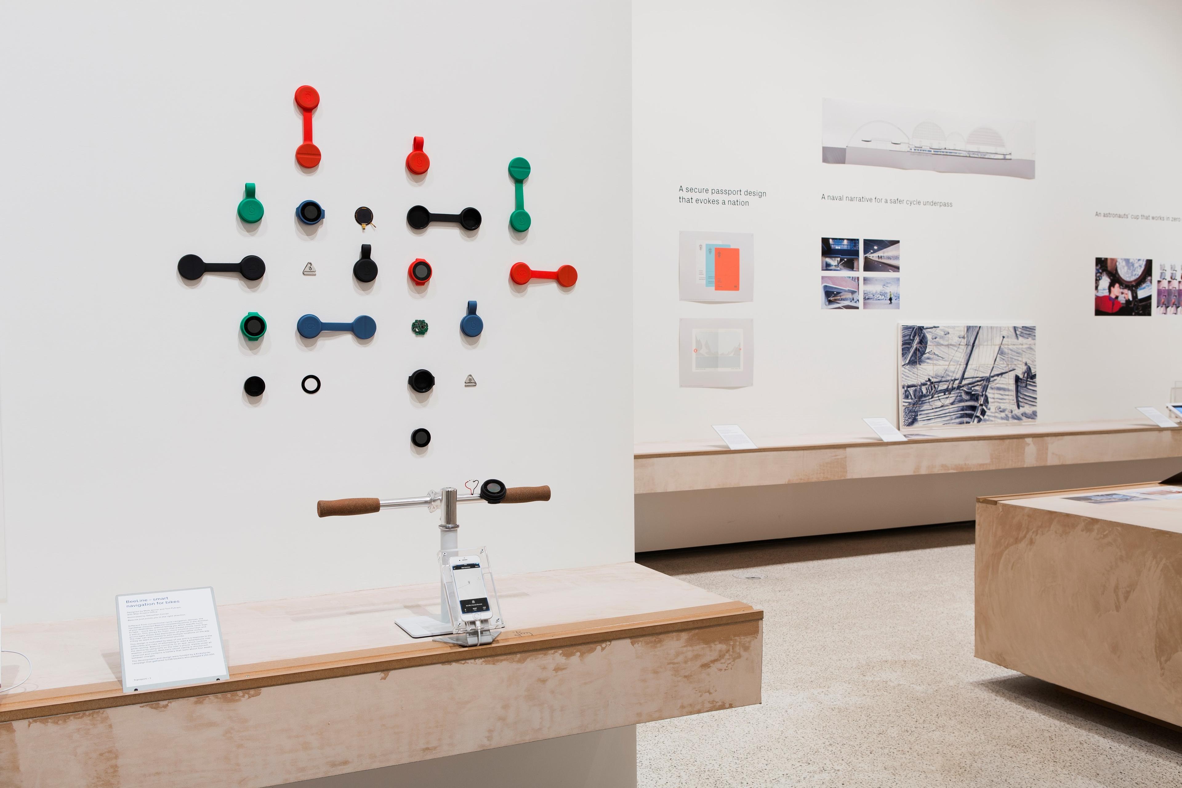 A photograph of a gallery in the Design Museum. Colourful objects are displayed on plaster coloured counters and white walls. 