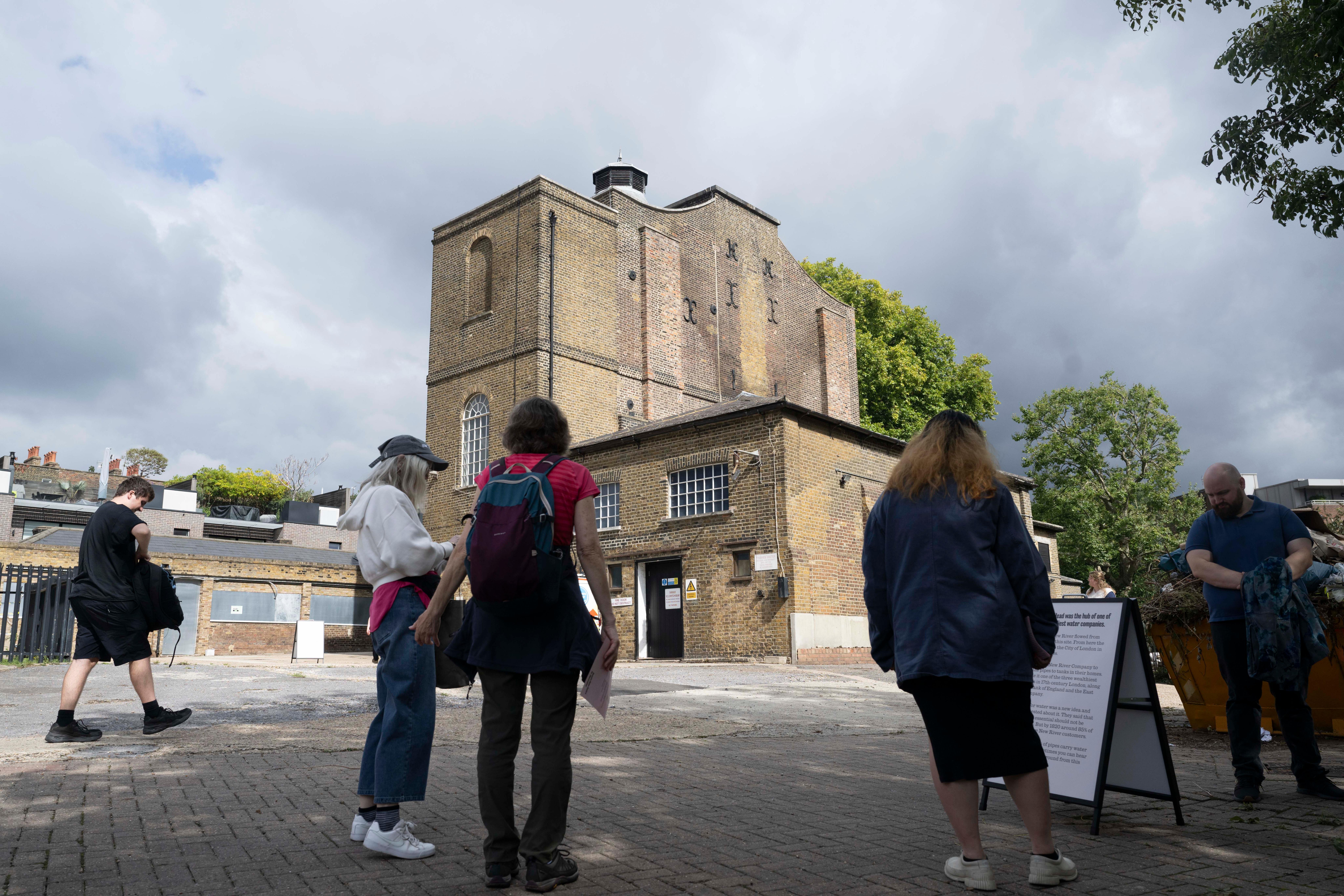 People standing in front of a derelict building.