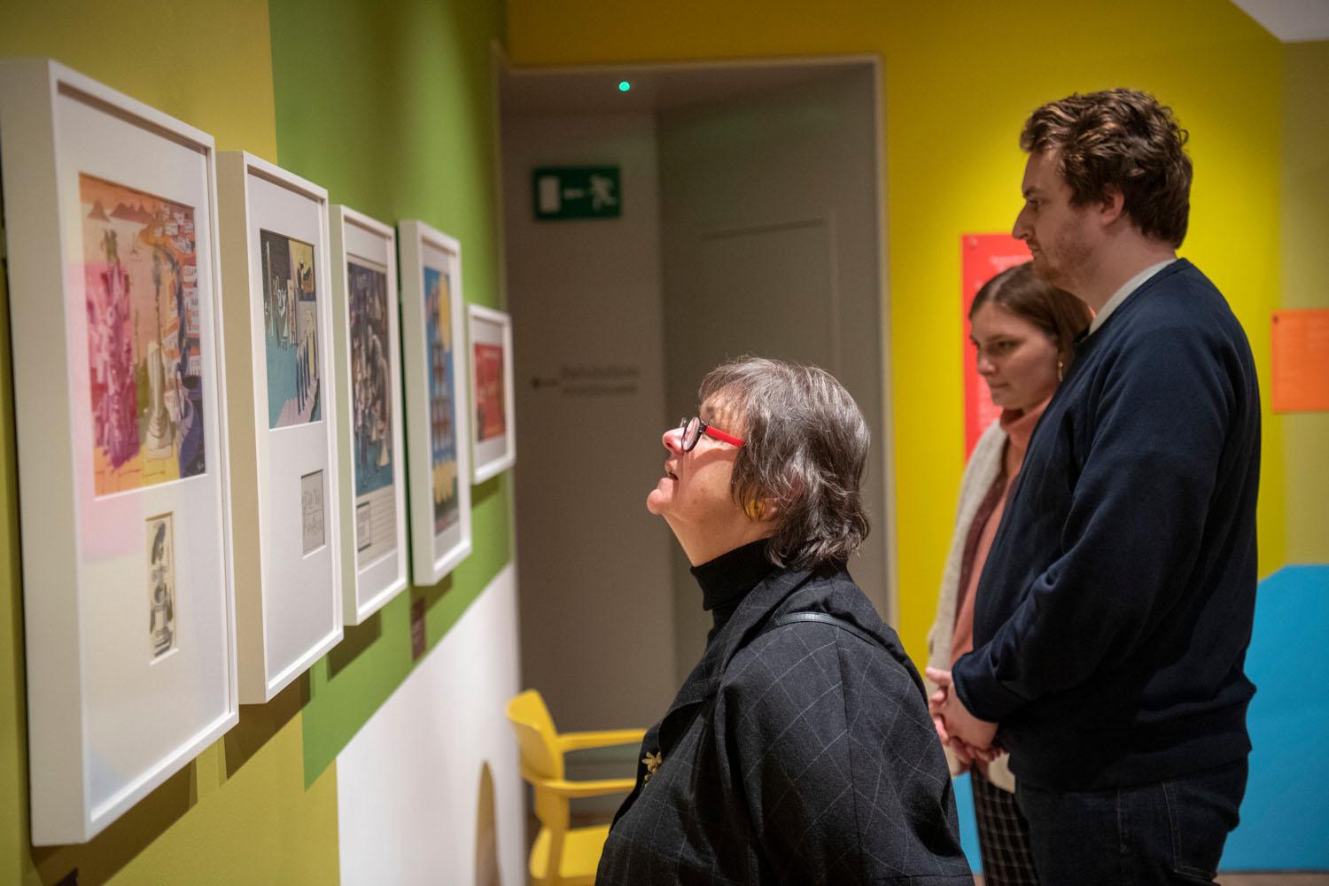 Visitors looking at artwork at the George Him exhibition