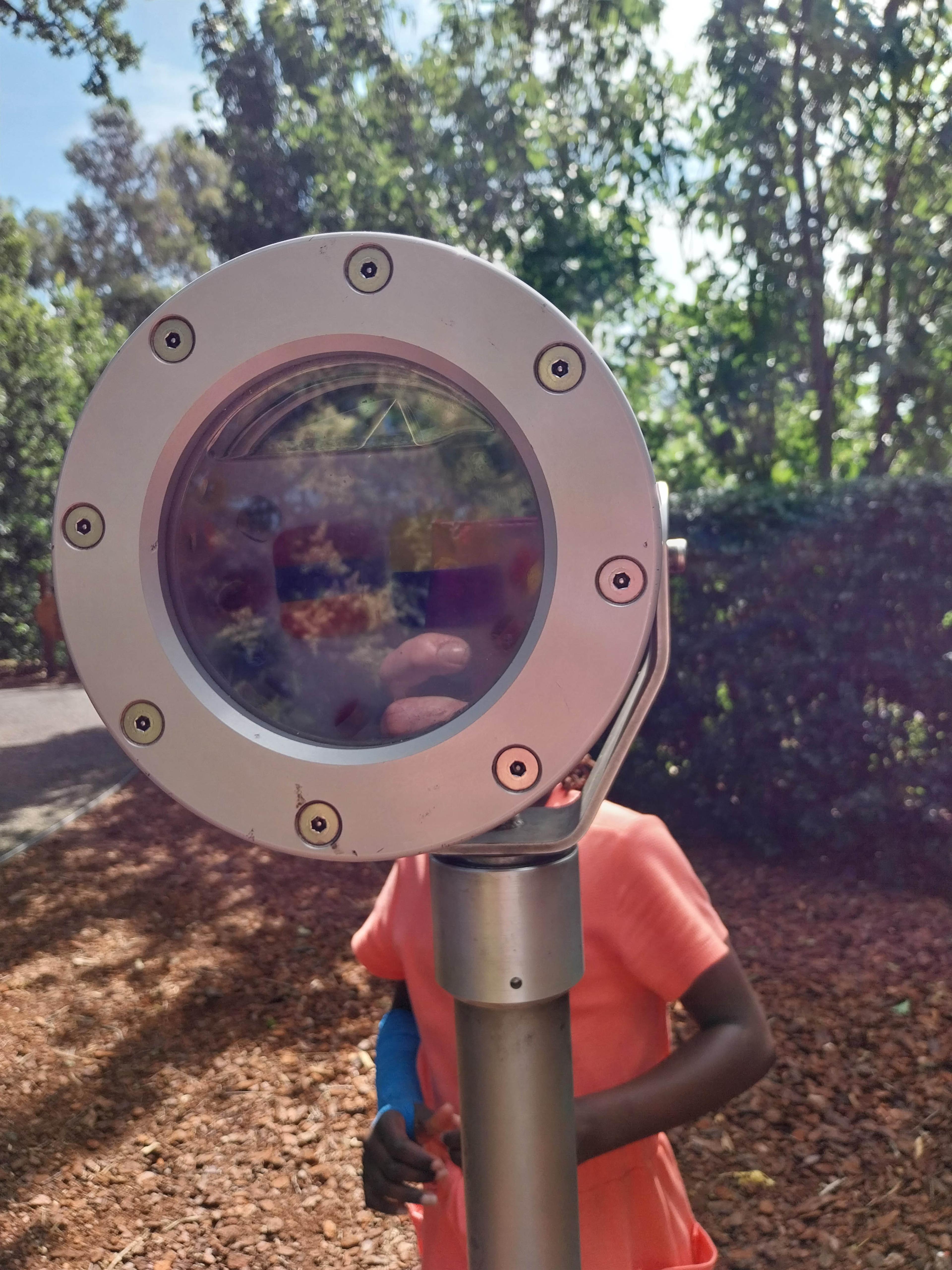 A large telegraph with a child standing behind it, their face is obscured.