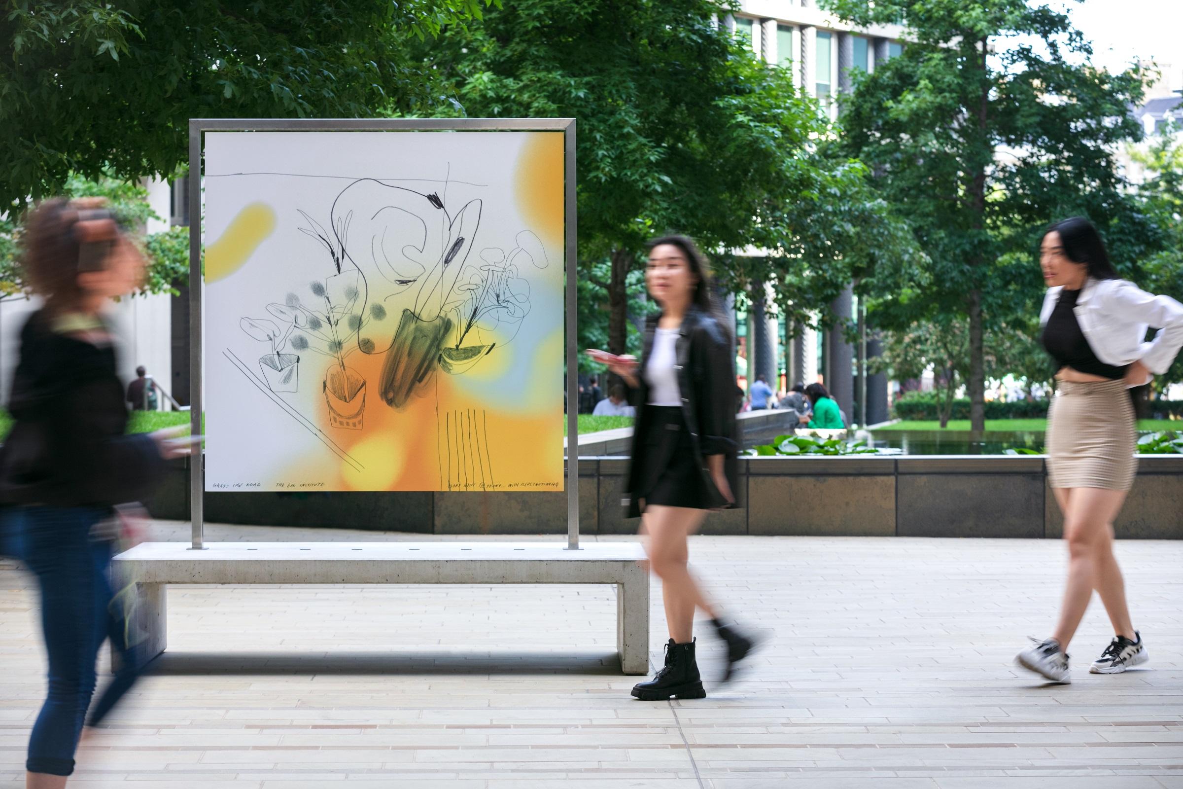 Large artwork mounted on a bench in surrounded by trees and people