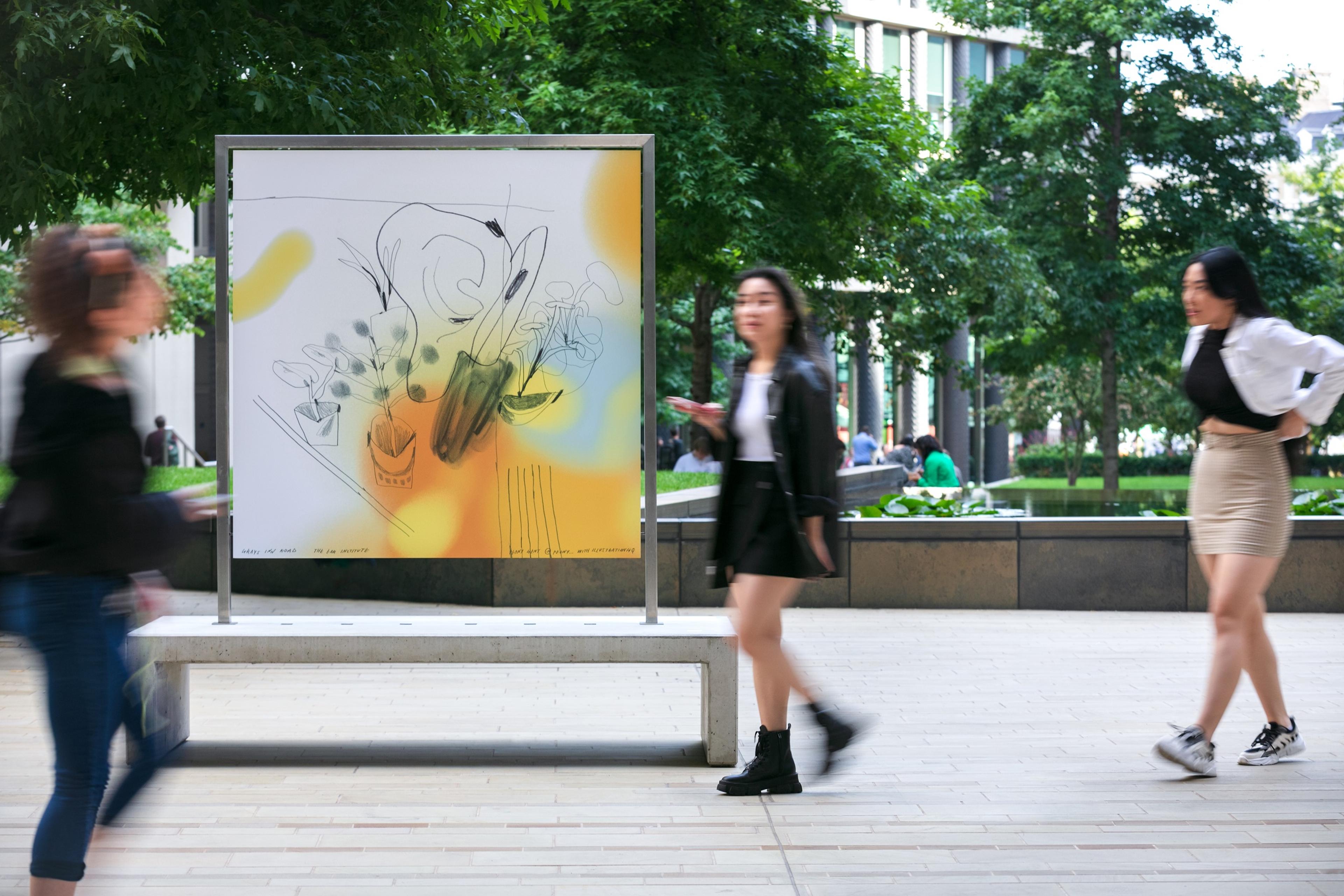 Large artwork mounted on a bench in surrounded by trees and people