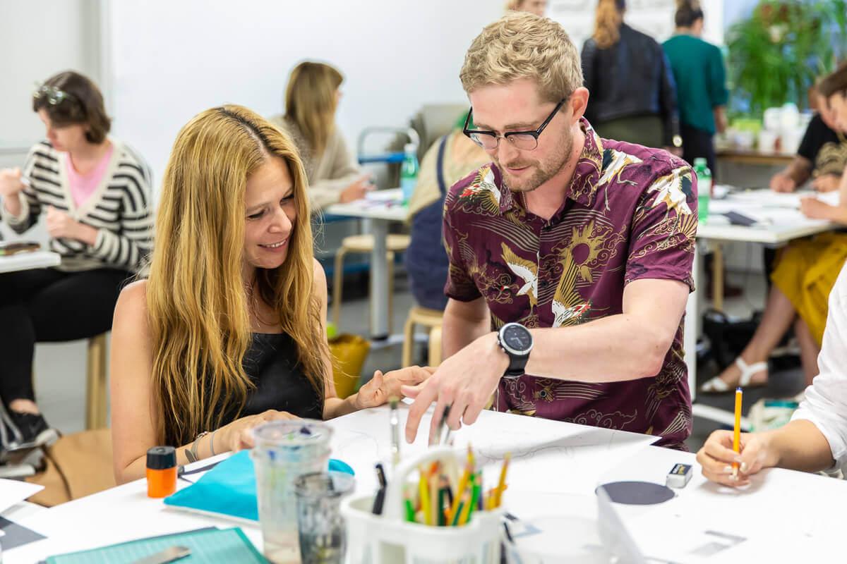 Two people drawing at a workshop
