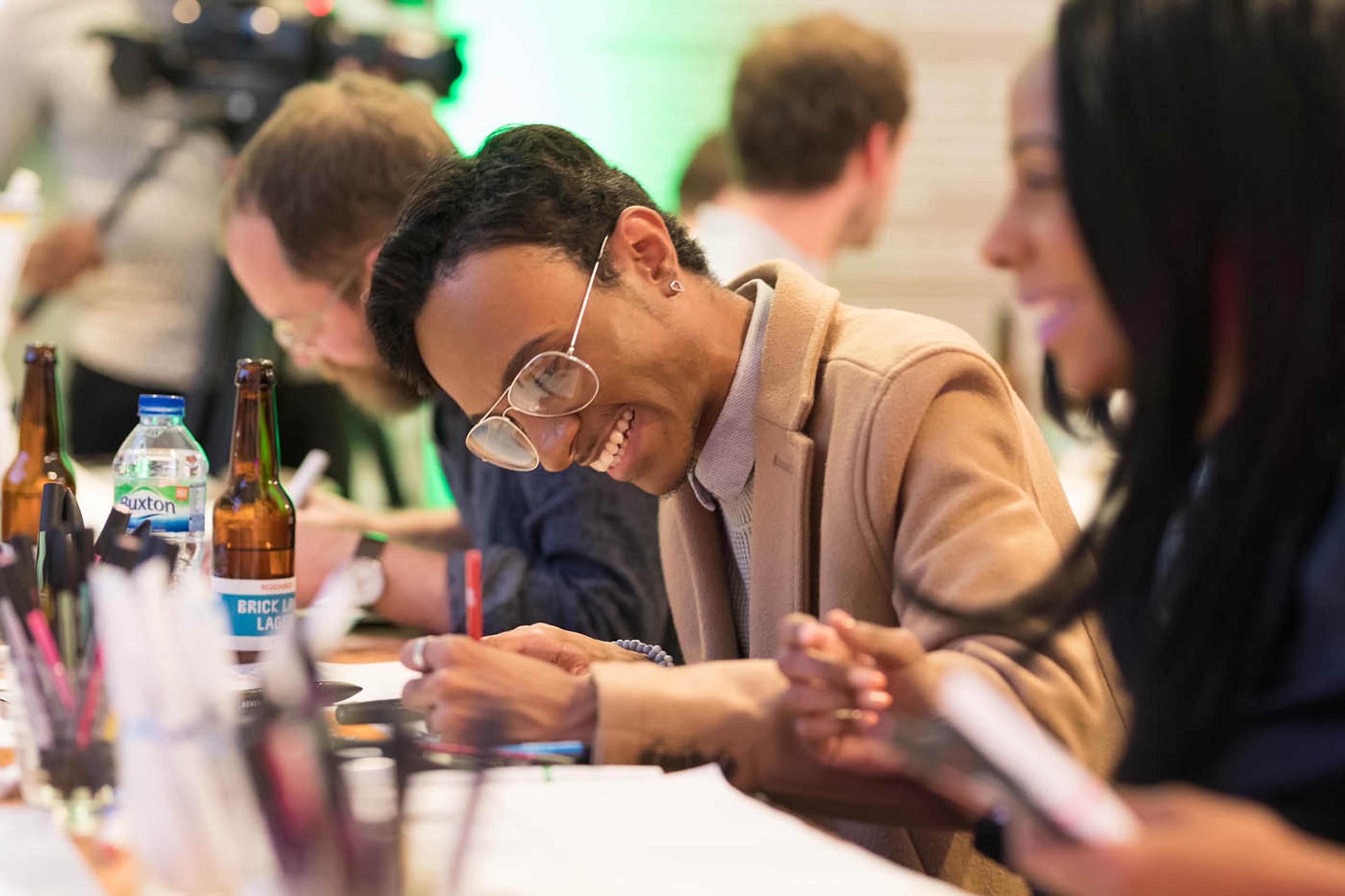 Photograph of people sitting at a table drawing