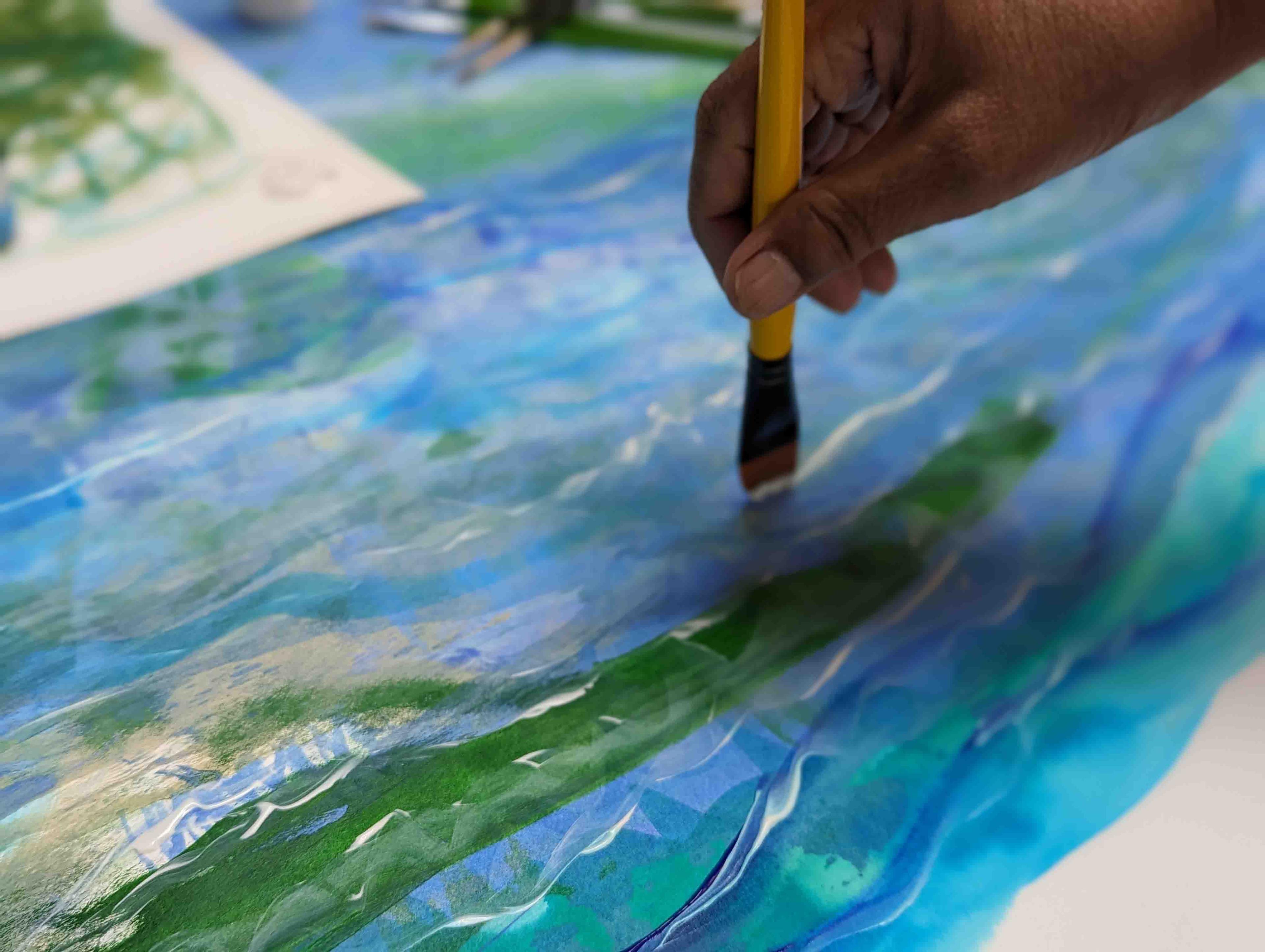 Close up of a paint brush painting on paper.