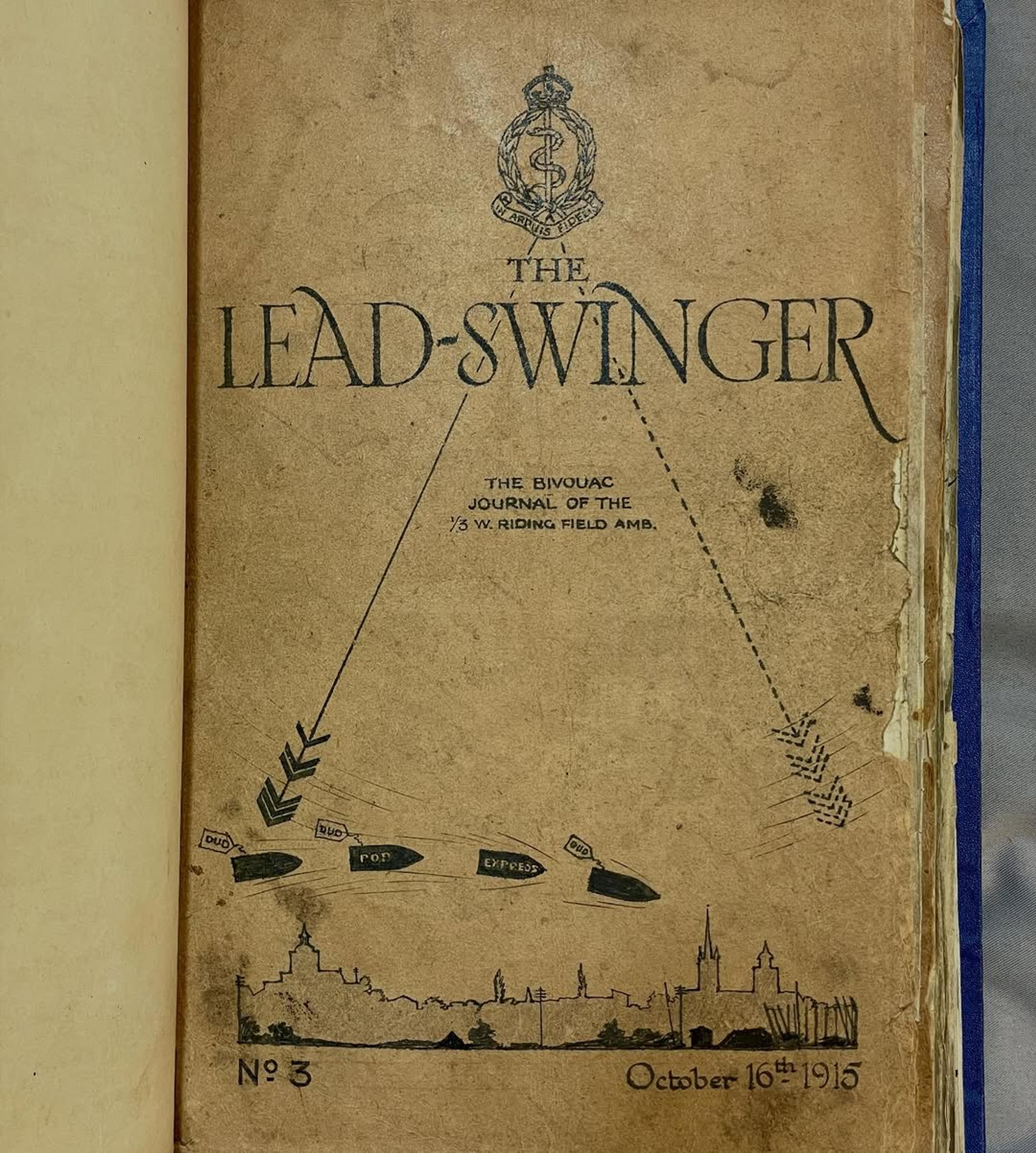 Vintage journal cover titled "The Lead-Swinger," dated October 16th, 1915, featuring military insignia, arrows, and a silhouette of a cityscape.