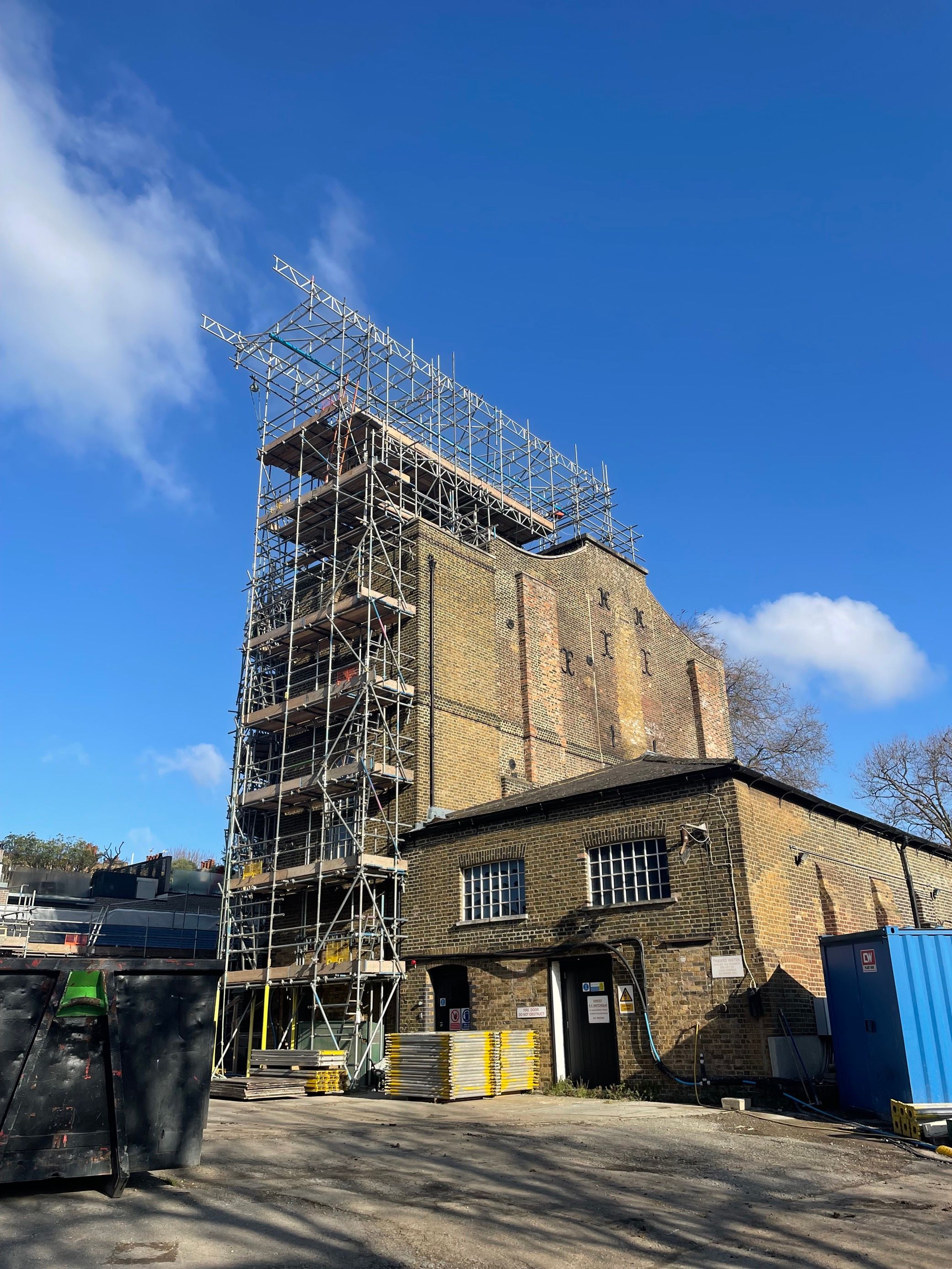 A photograph of a brick engine house with scaffolding on the outside 