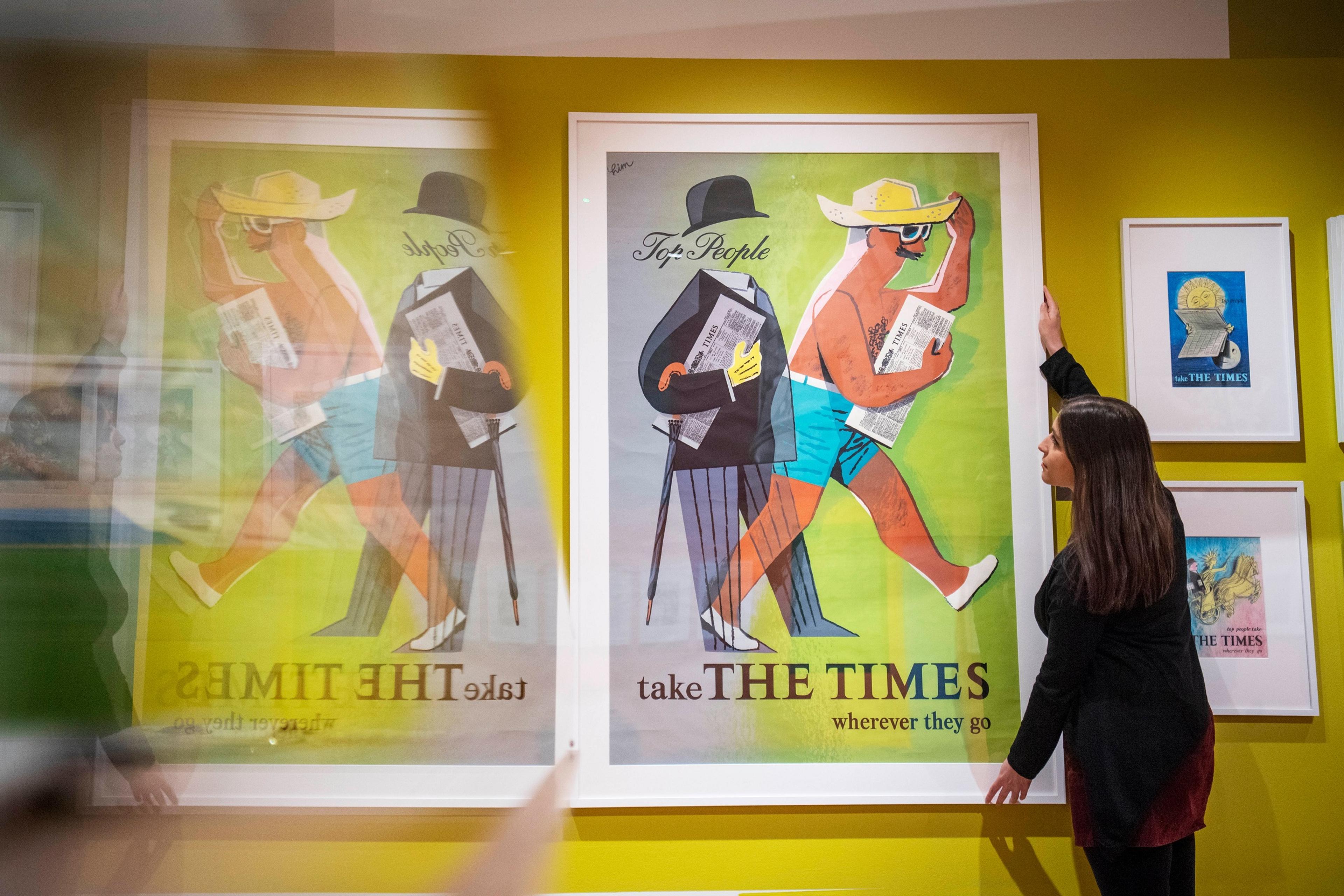Photograph of person putting up large picture frame containing poster