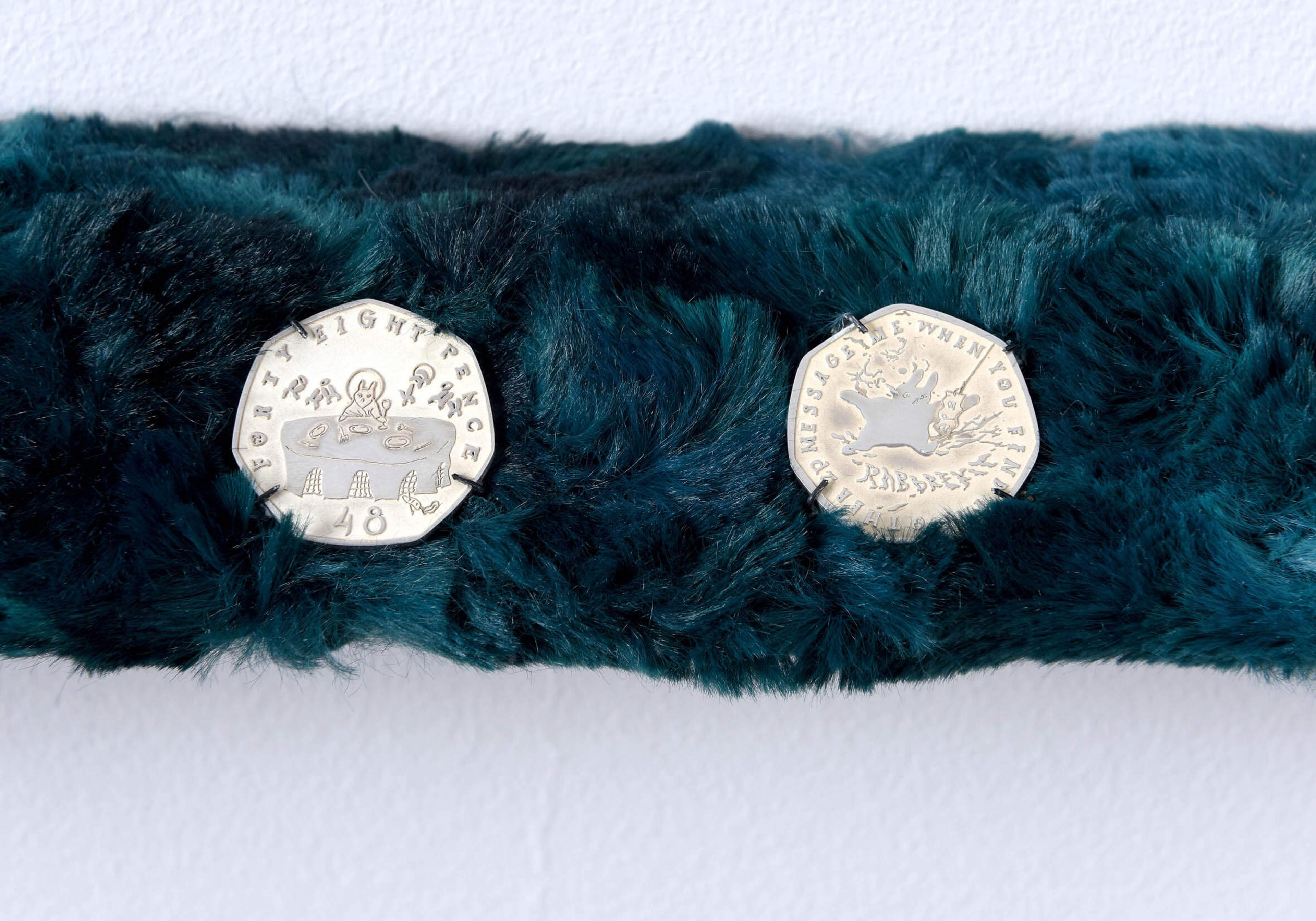 Engraved 48p coins commemorating Rabbrexit, displayed upon fluffy teal fabric