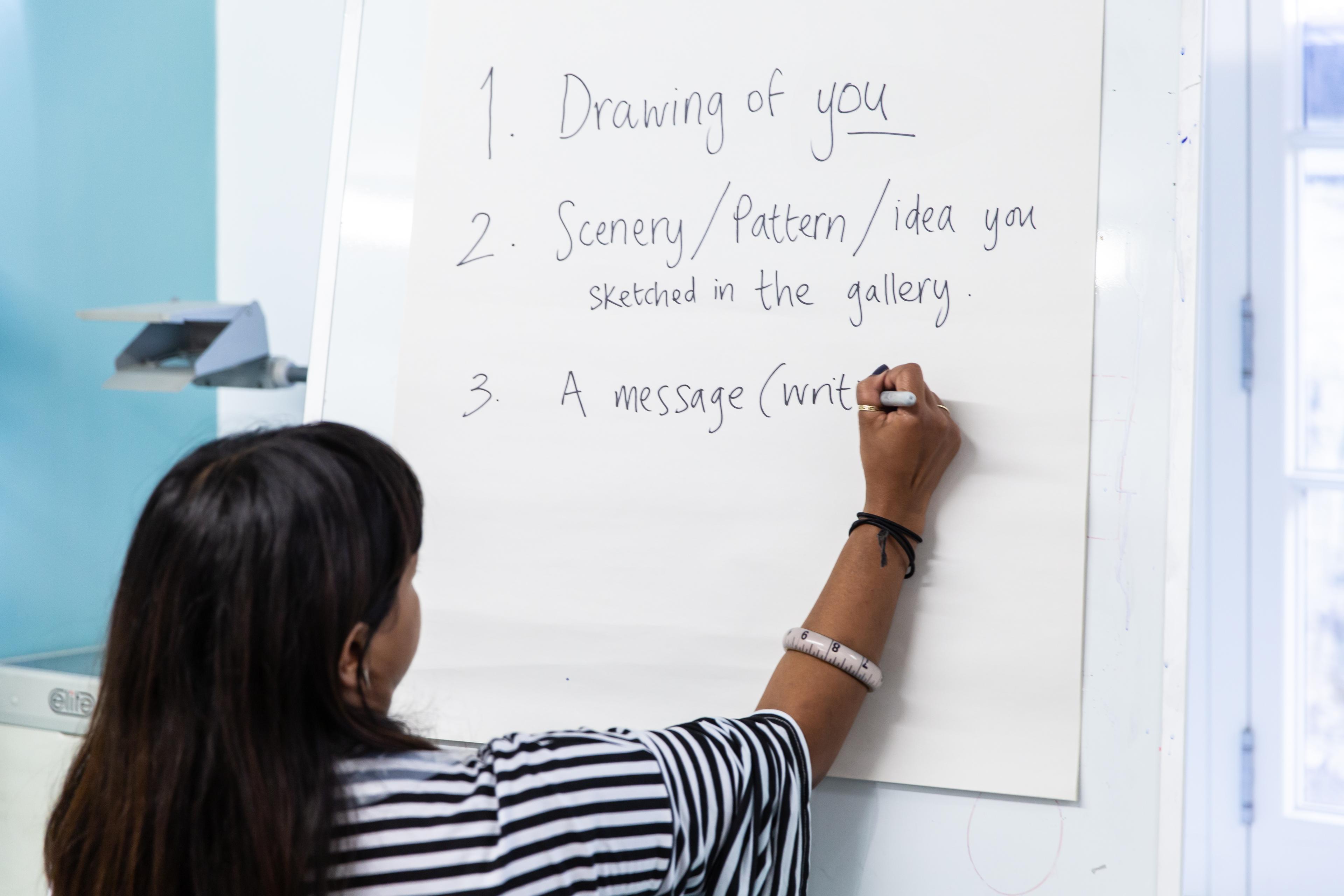 Photograph of person writing activity instructions on flipchart paper