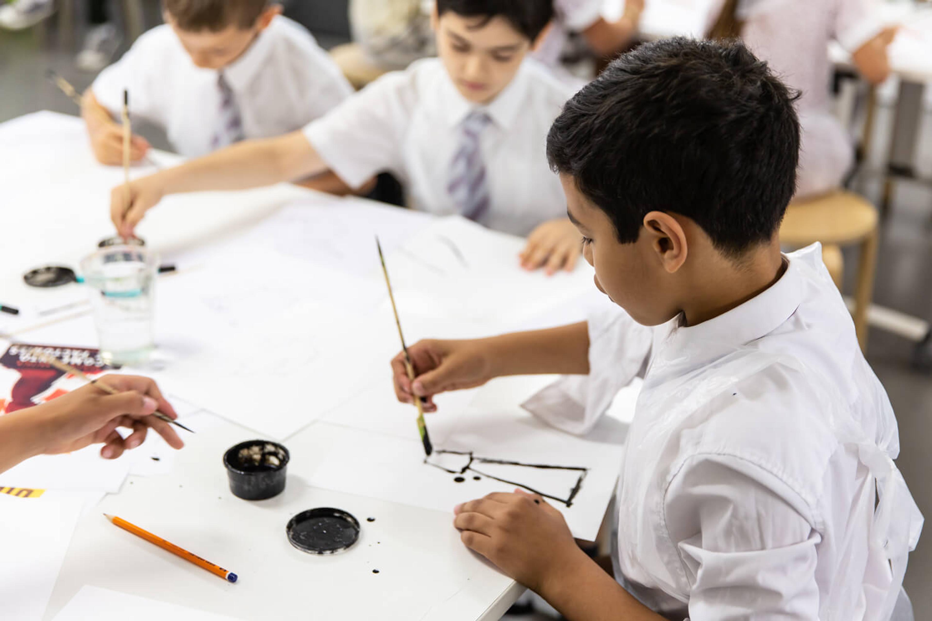 Photograph of 3 school pupils sitting at a table drawing