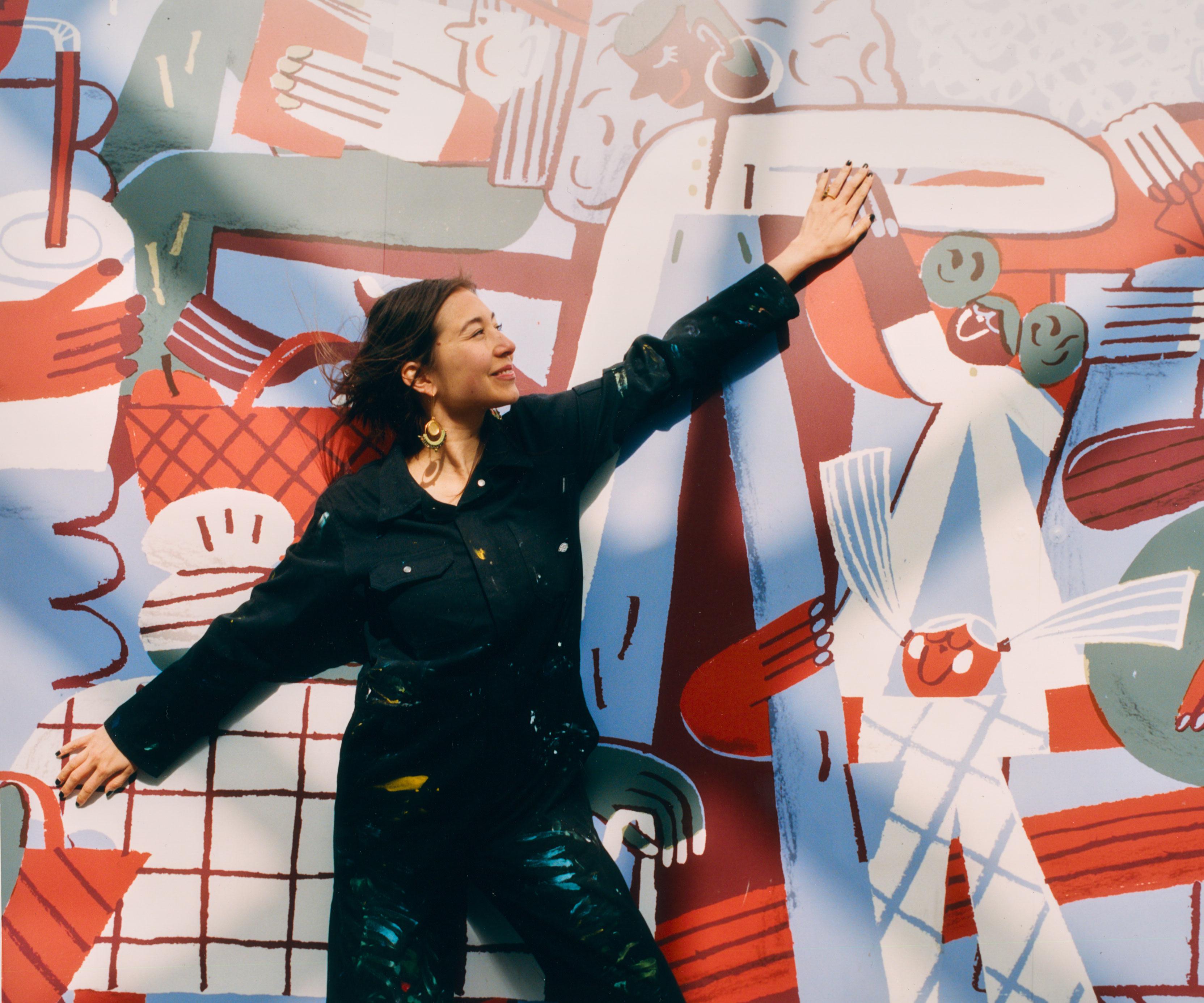 Person standing with their arms open in front of an illustrated wall