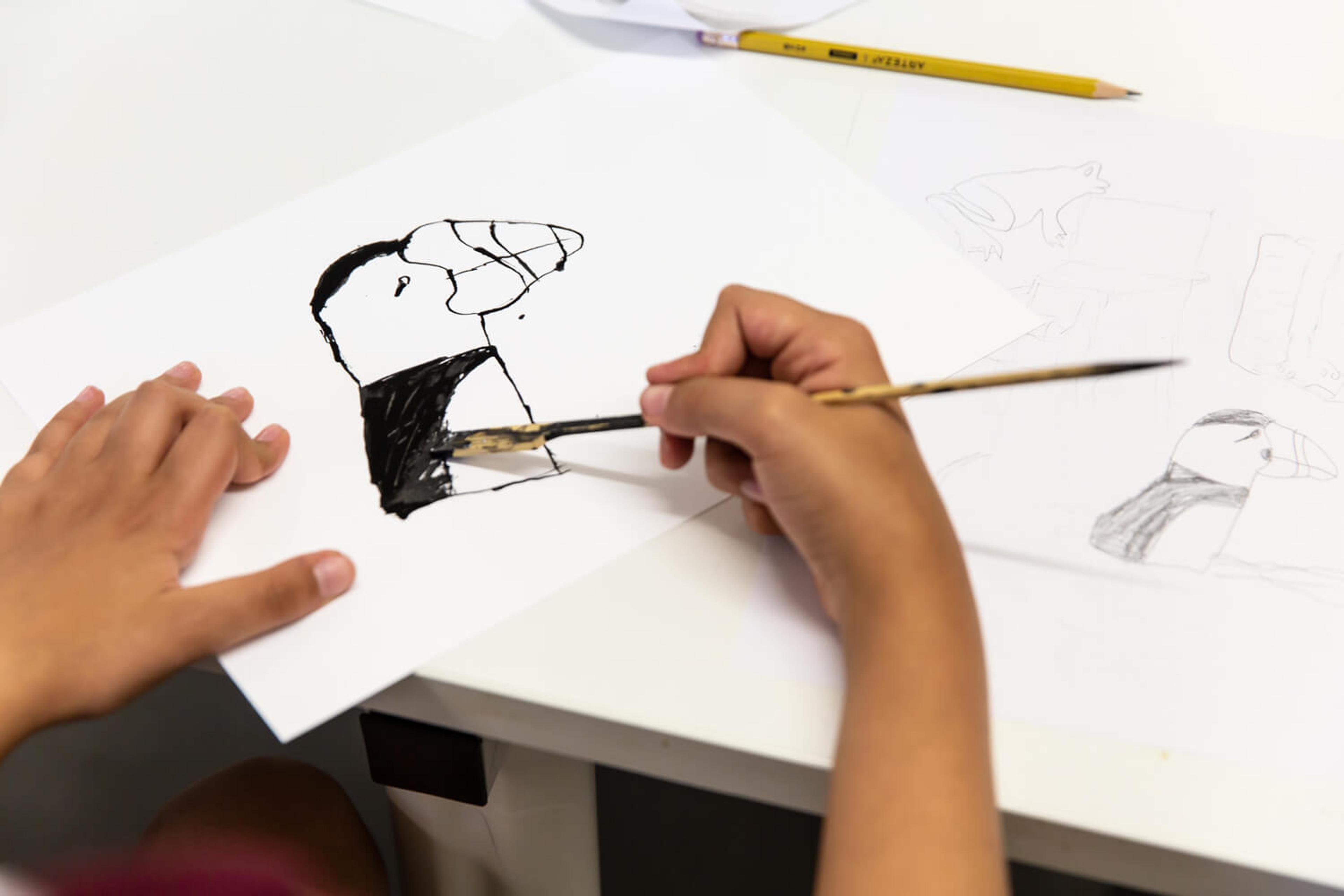 Photograph of school pupil looking at printout of poster of woman showing bicep and the text ‘we can do it’