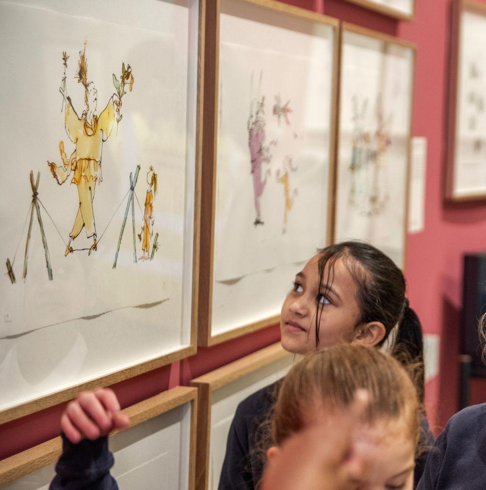 Two young people looking at a display case and drawing