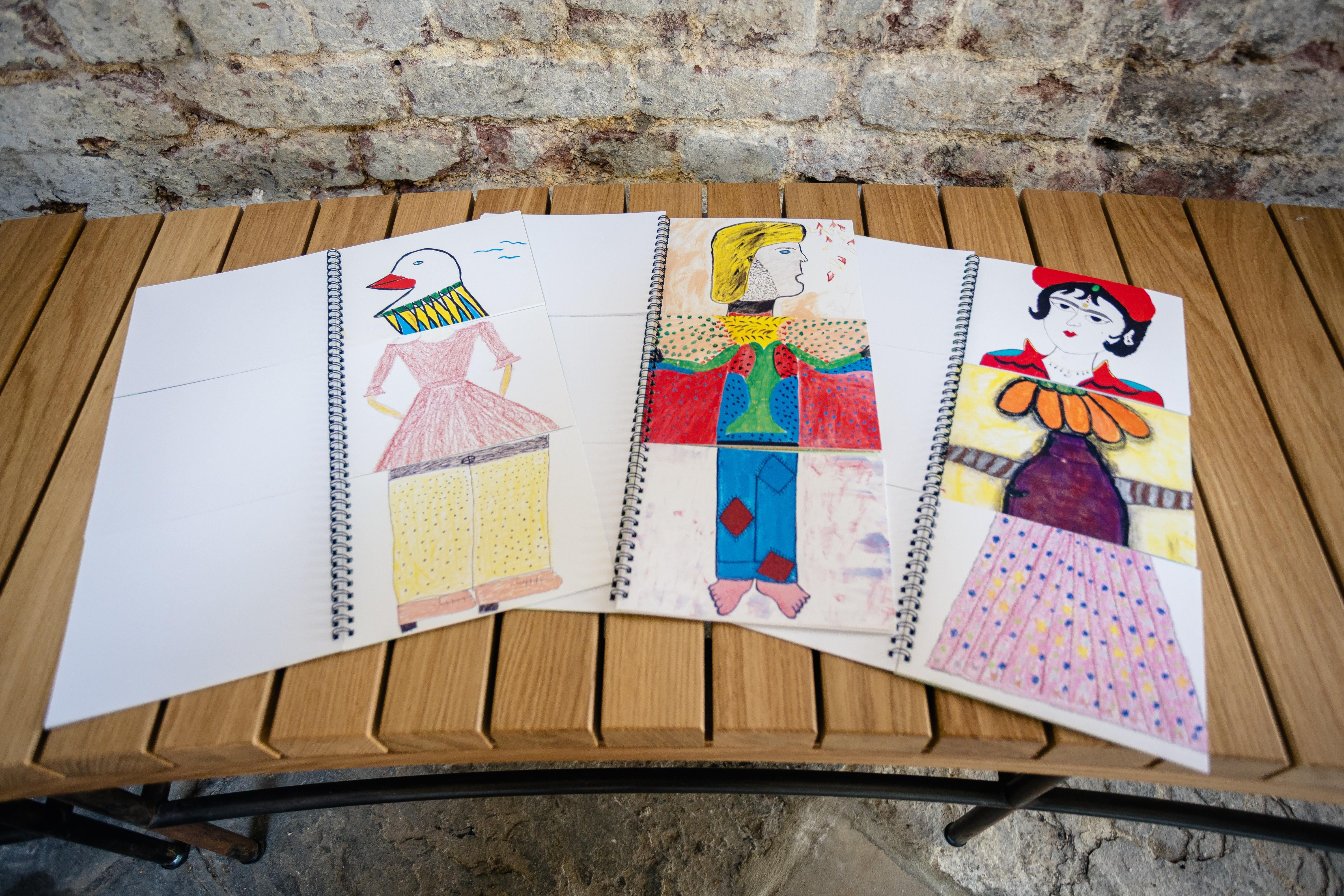 Three open flip books with drawings of a different head, body and feet.