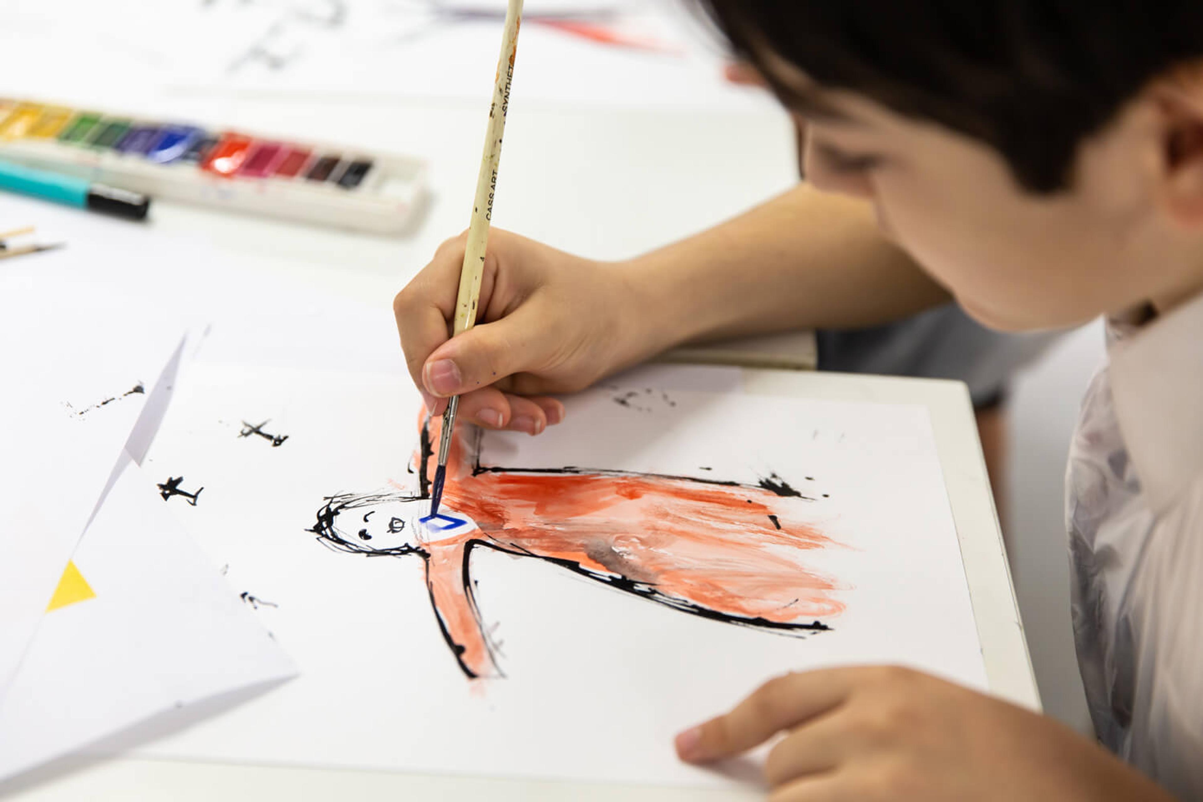 Photograph of a child illustrating with a paint brush
