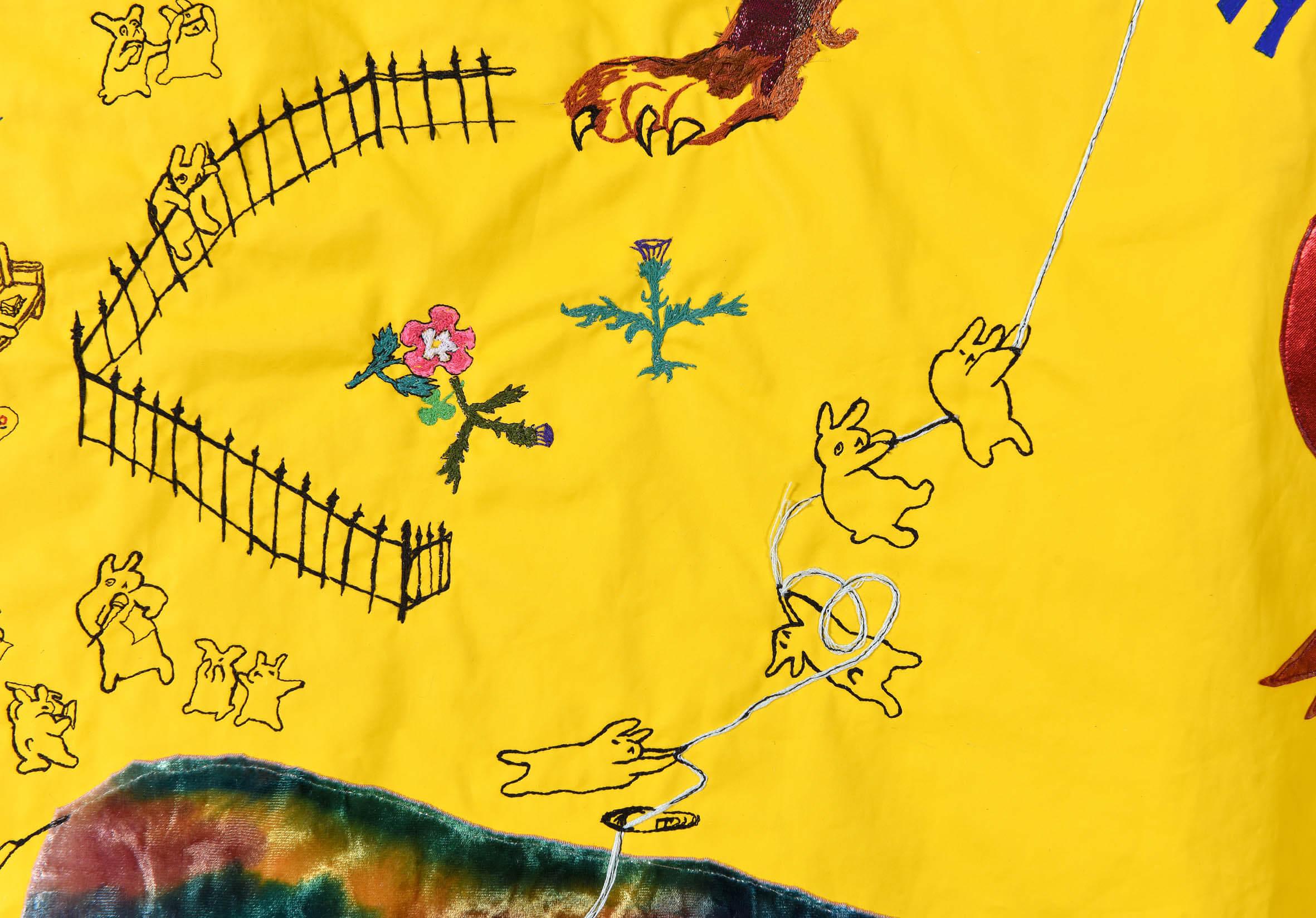 Detail of an embroidered yellow tapestry