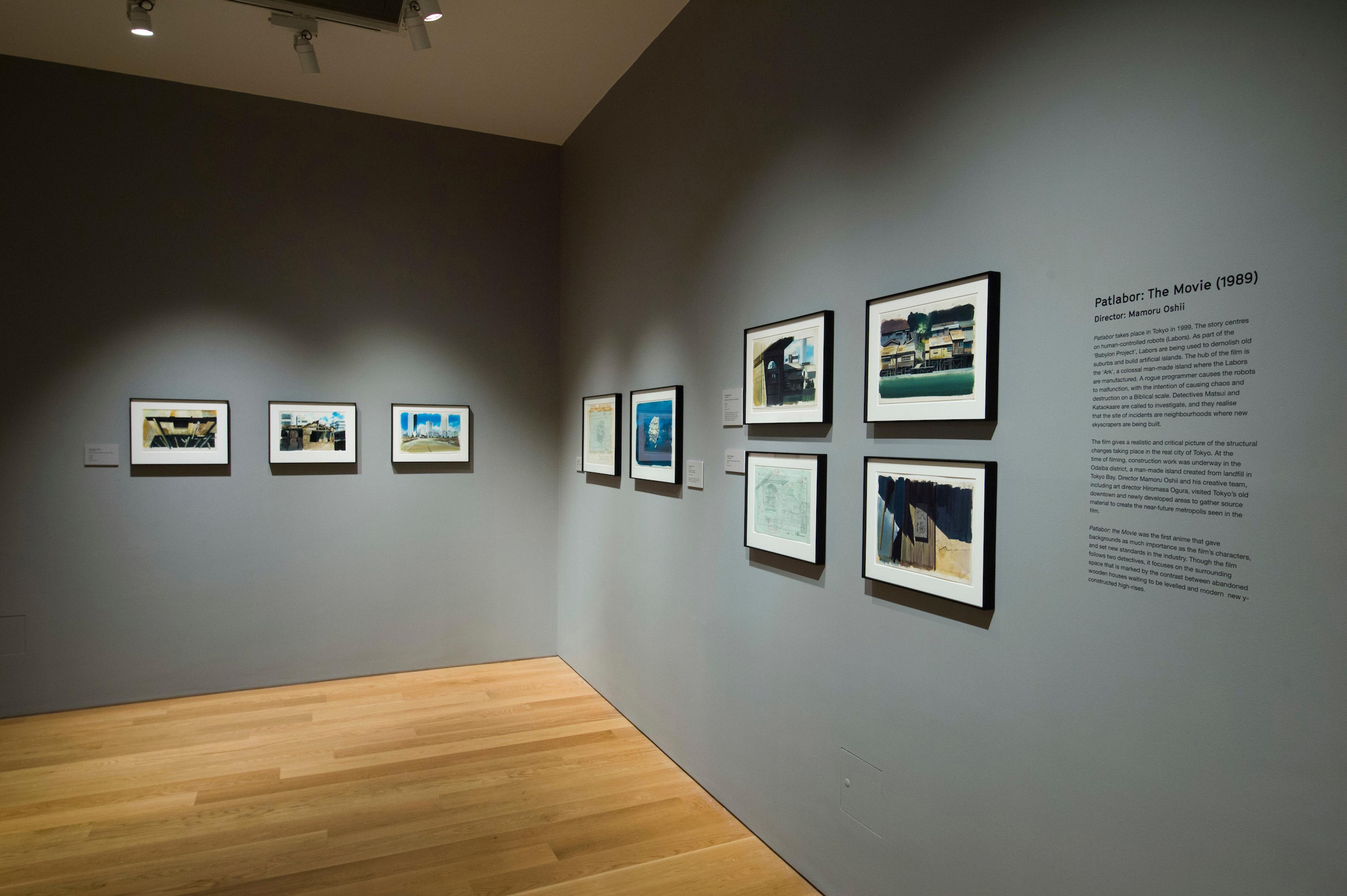 Framed illustrations and text displayed on a wall in a gallery space.