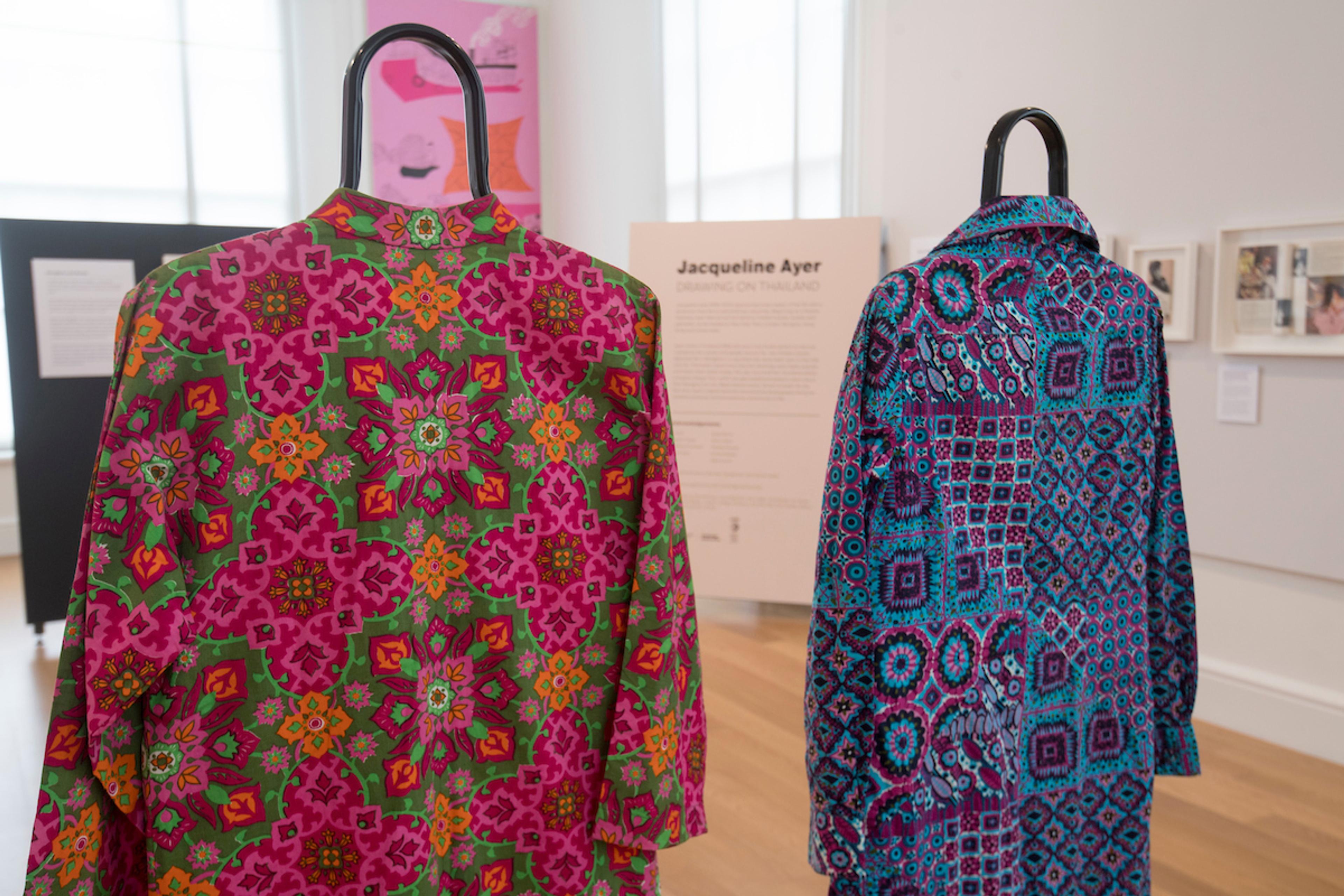 Two patterned outfits in an exhibition space.