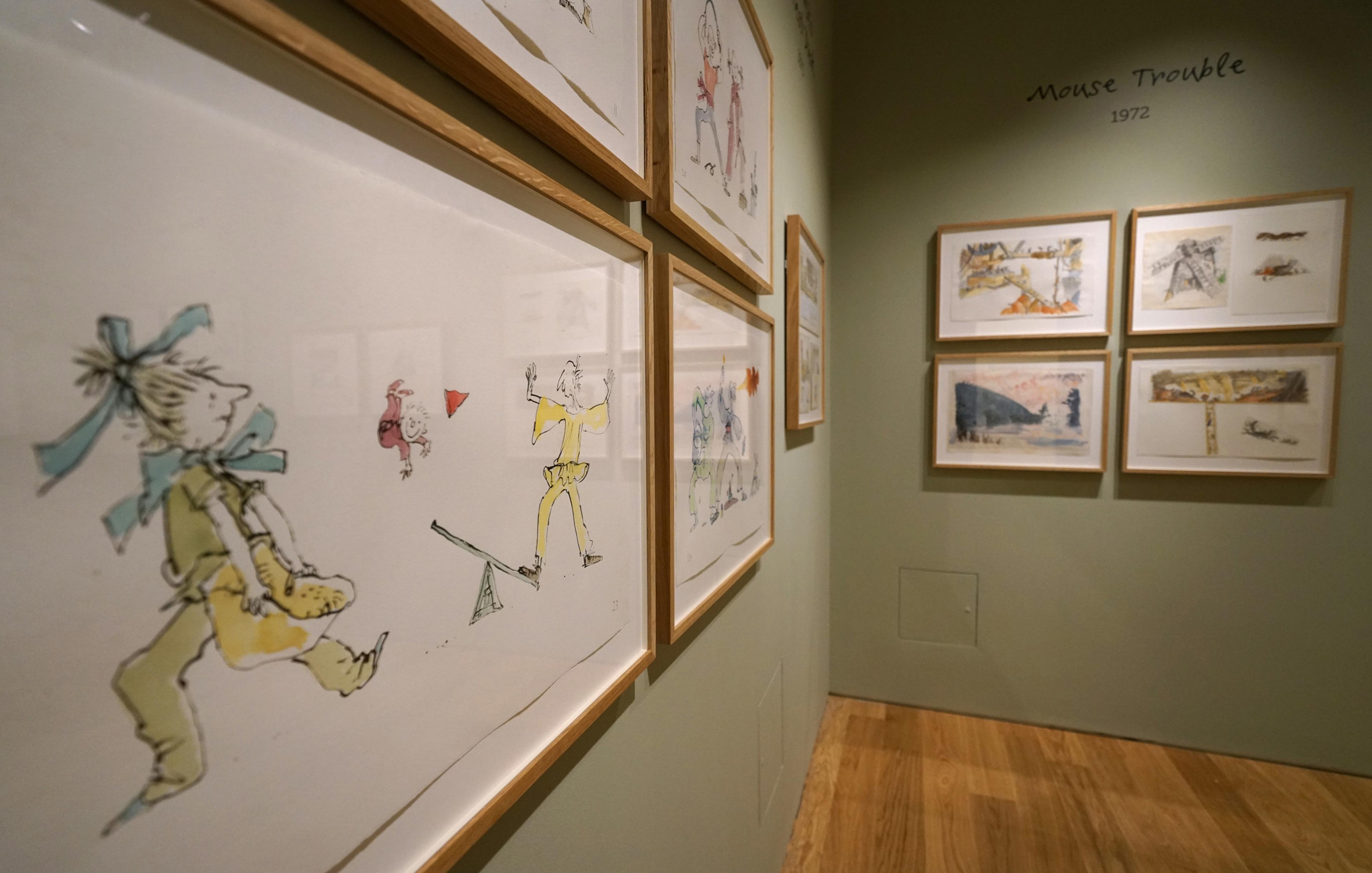 Framed illustrations on the walls of a gallery space.