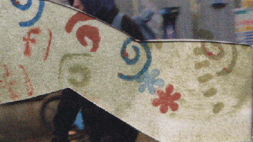 A mixed media video in which two people pull a floaty collage of patterns down a rainy London street.