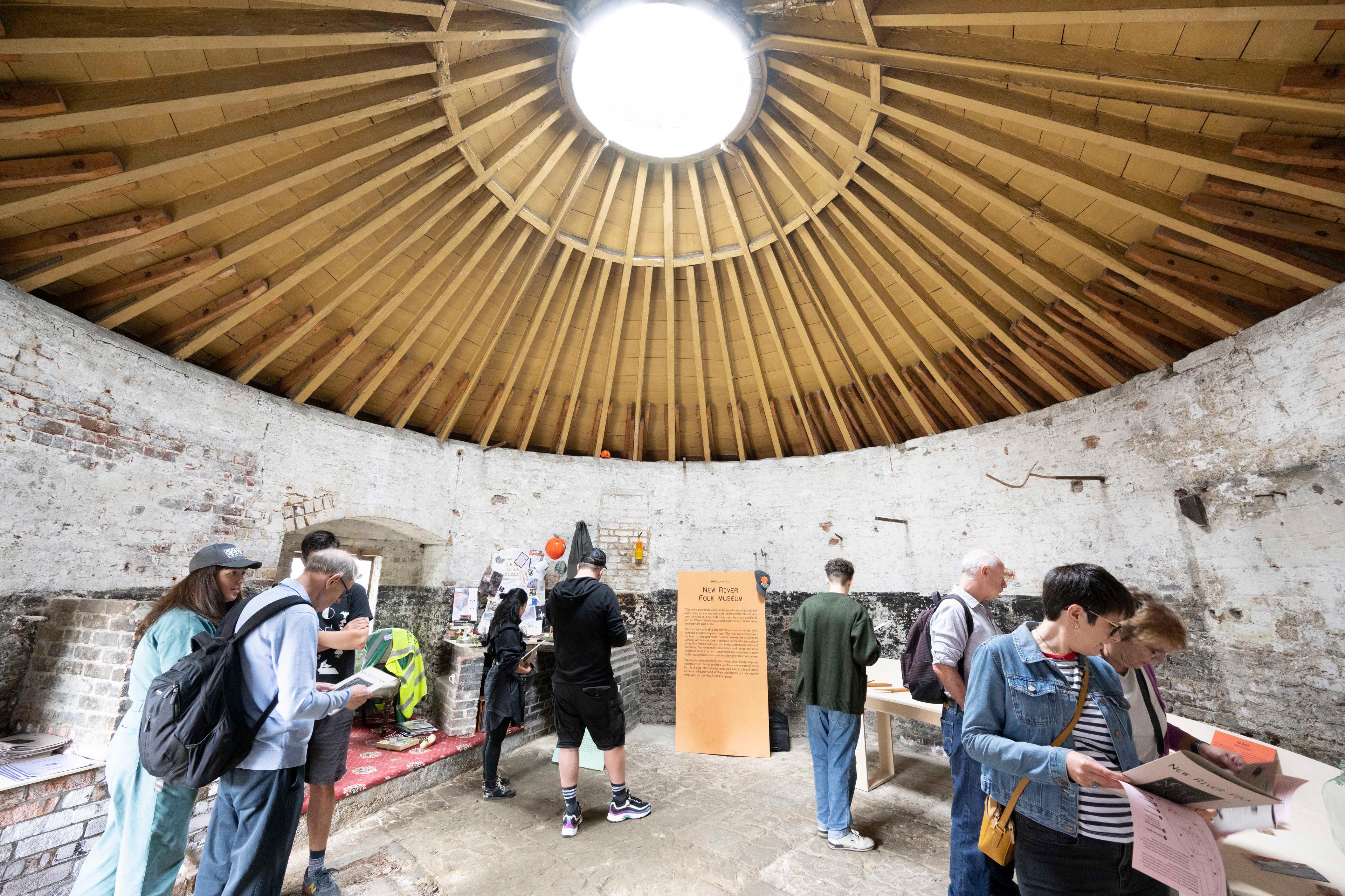 People standing inside of the base of a windmill. 