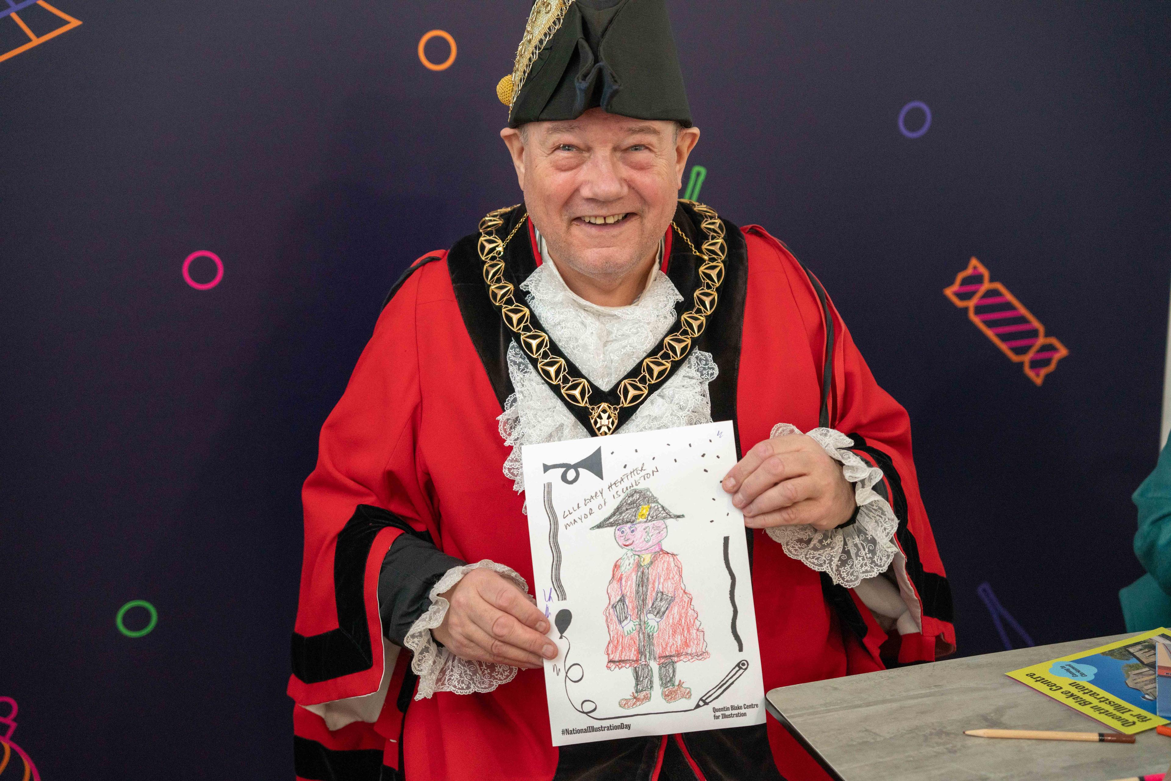 Photograph of the Mayor of Islington holding an illustration of himself.