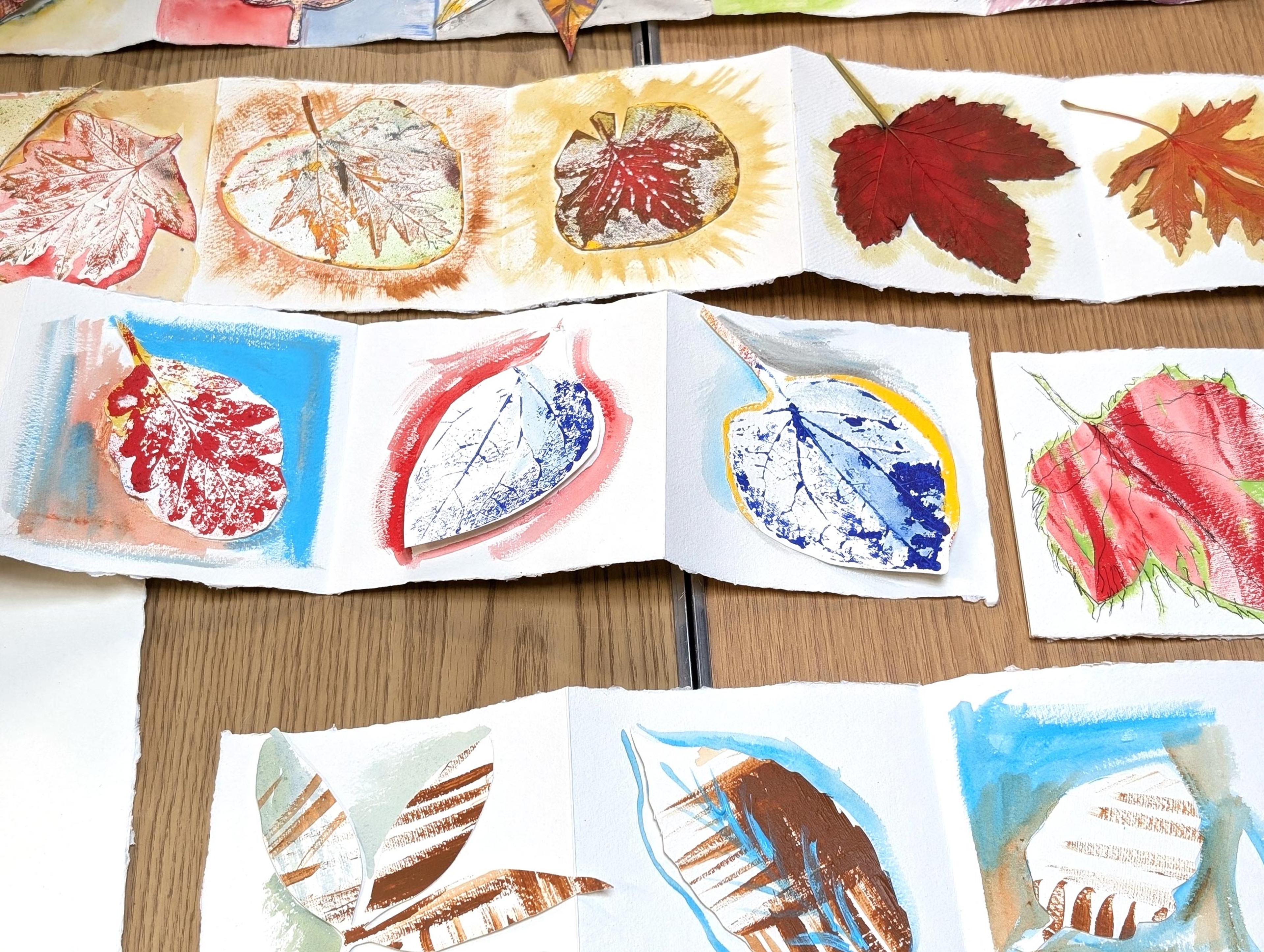 A table covered in colourful illustrations of different leaves. 