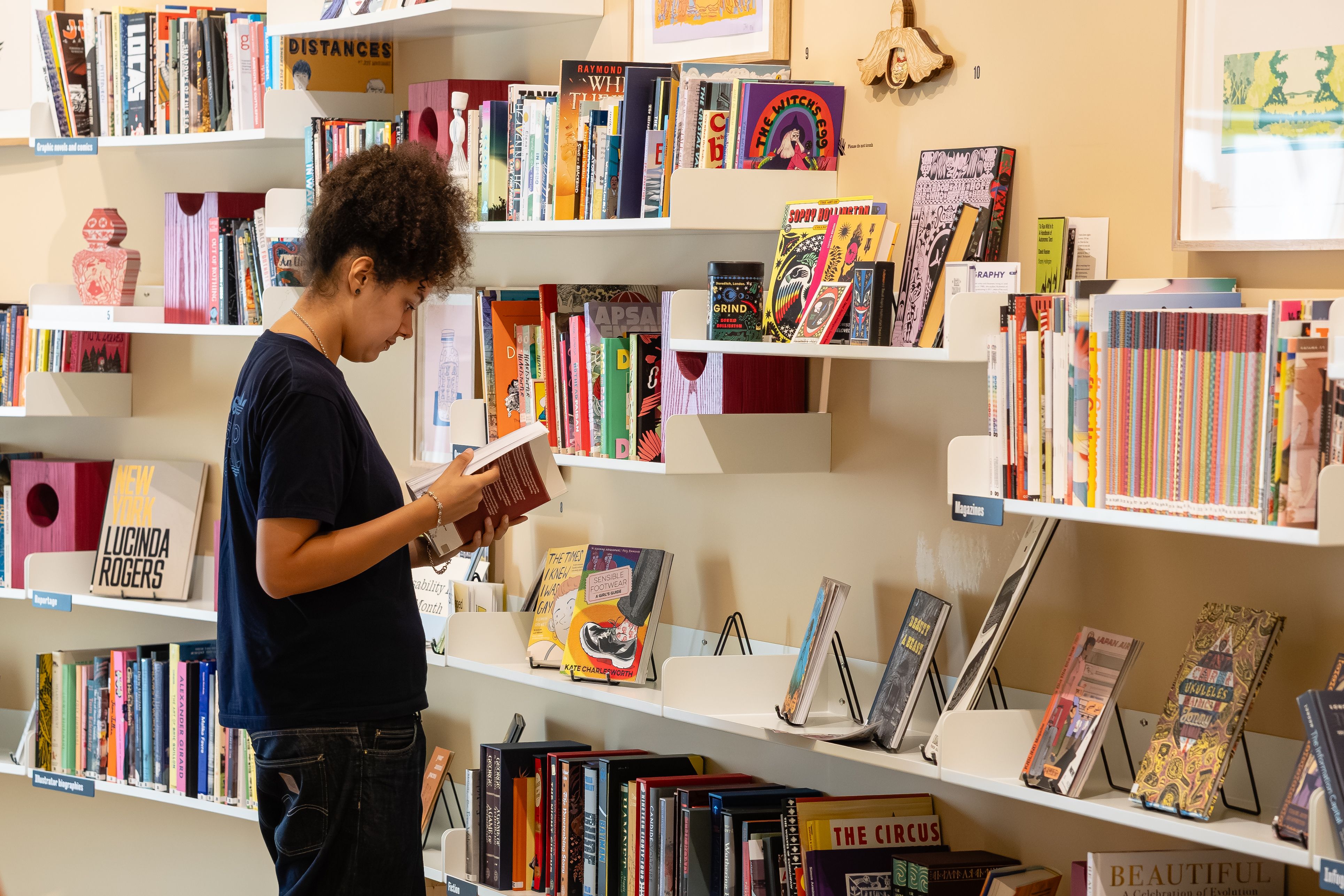 A person reads a book in a library.