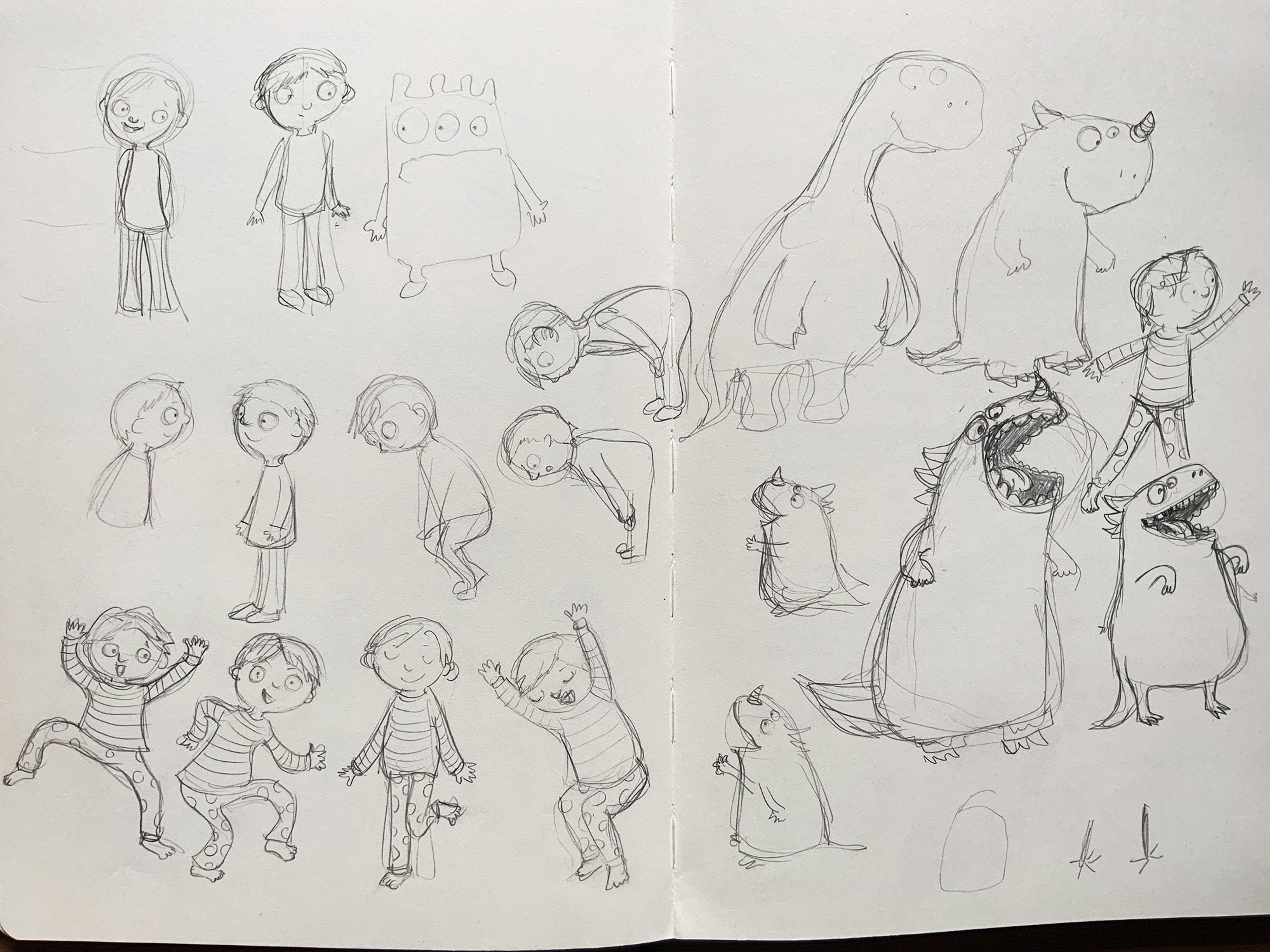 An open sketch book with character drawings drawn on both pages in pencil.