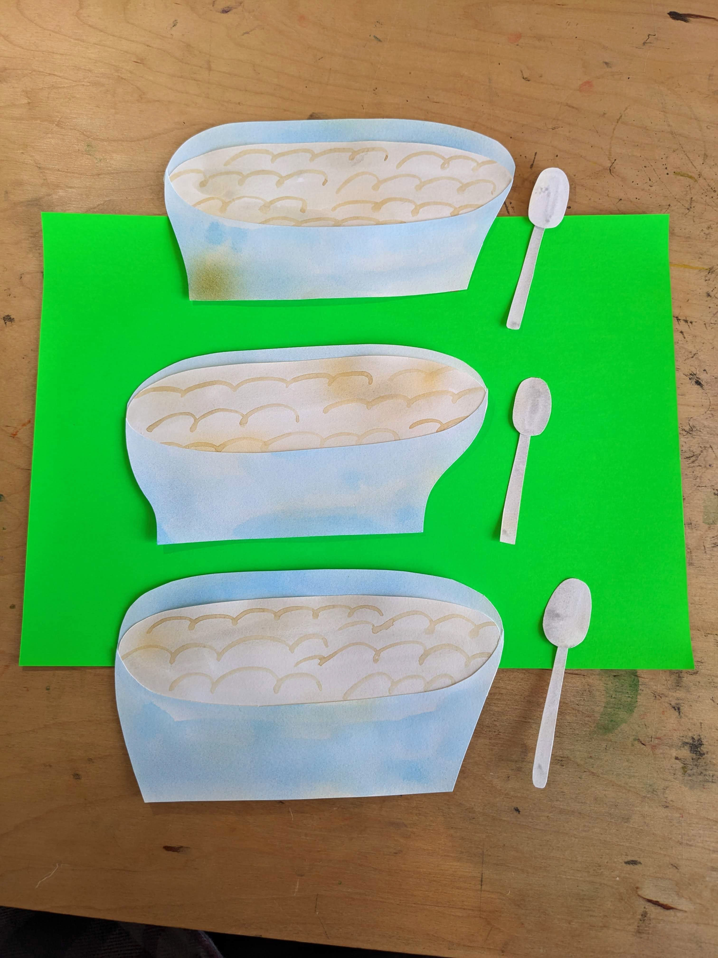 Illustrations of three bowls of porridge with spoons on a green piece of paper on top of a table.