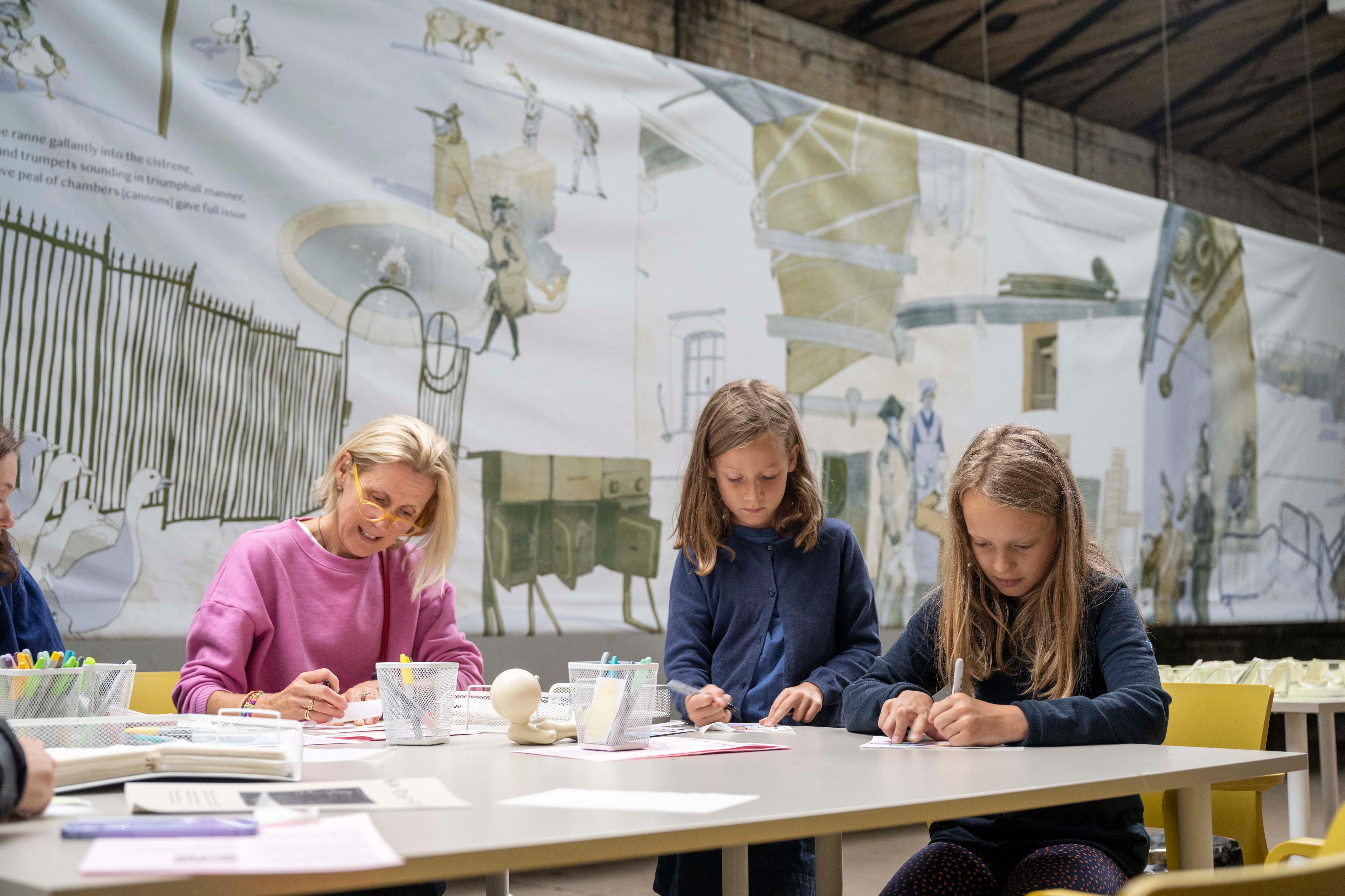 Photograph of people creating art at a table.