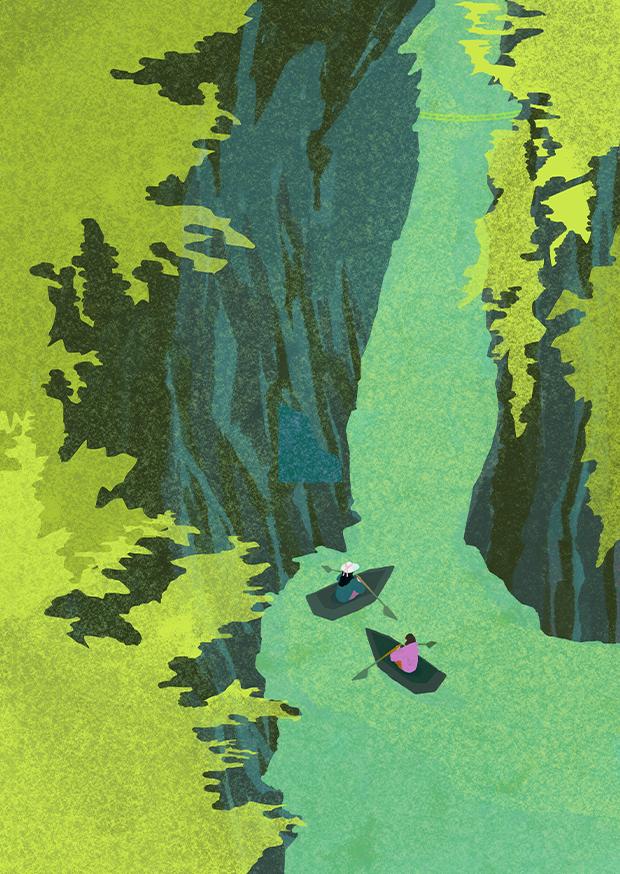 A birds eye view of a gorge with two people kayaking along green water. There is green foliage at the top of the mountain.
