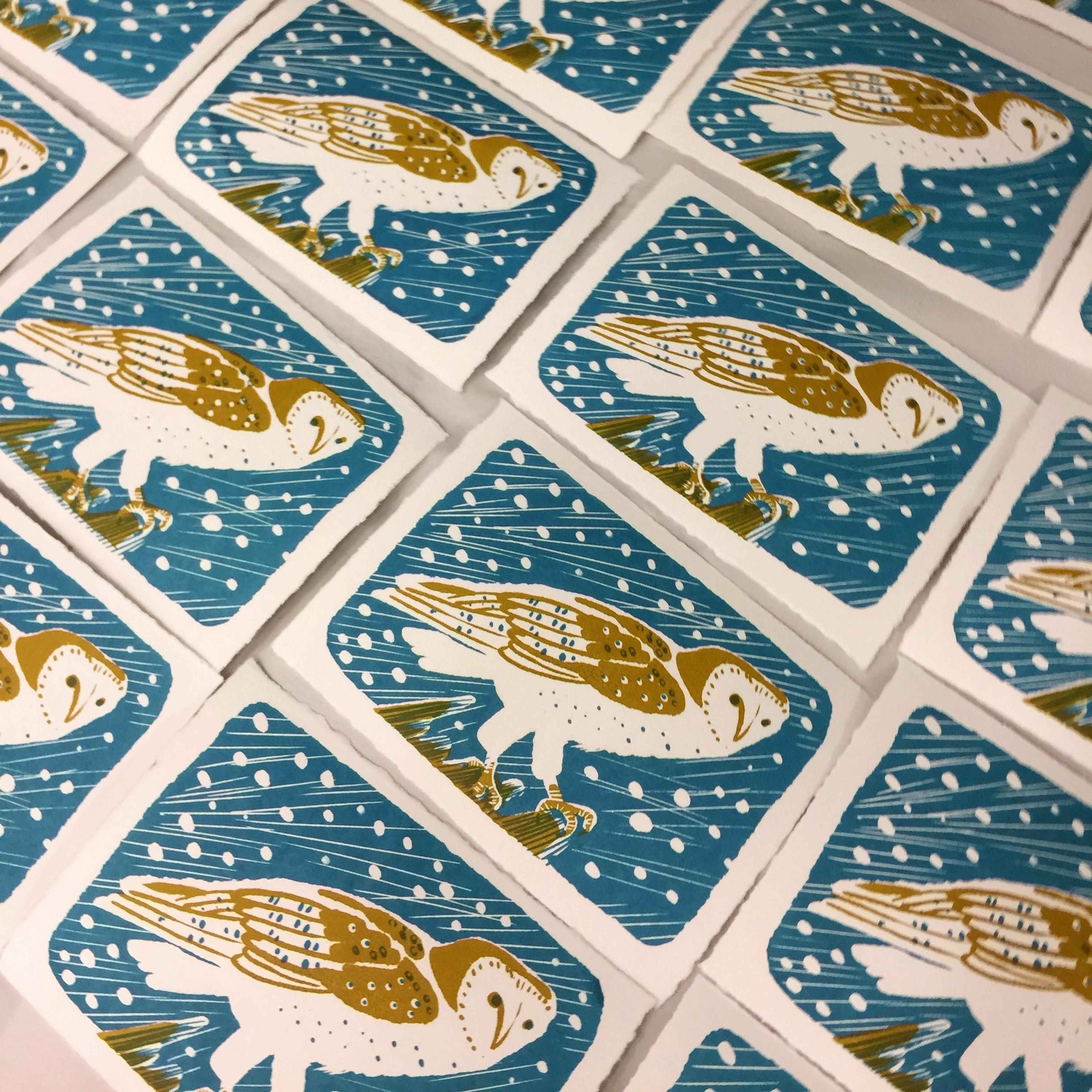 Multiple prints of an owl against a blue background with white spots.
